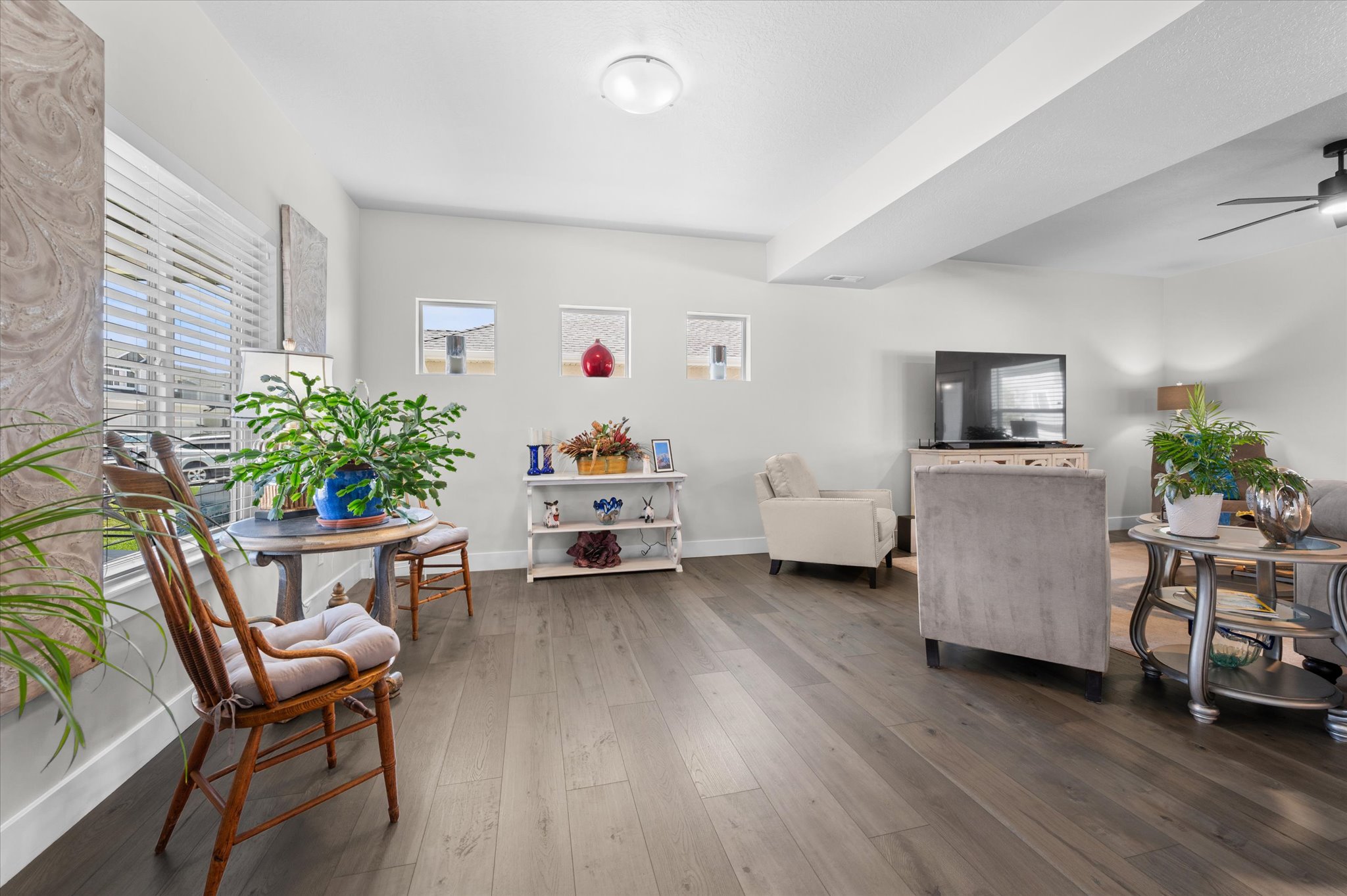 Spacious living area featuring wood-finish flooring, recessed lighting, and large windows with blinds