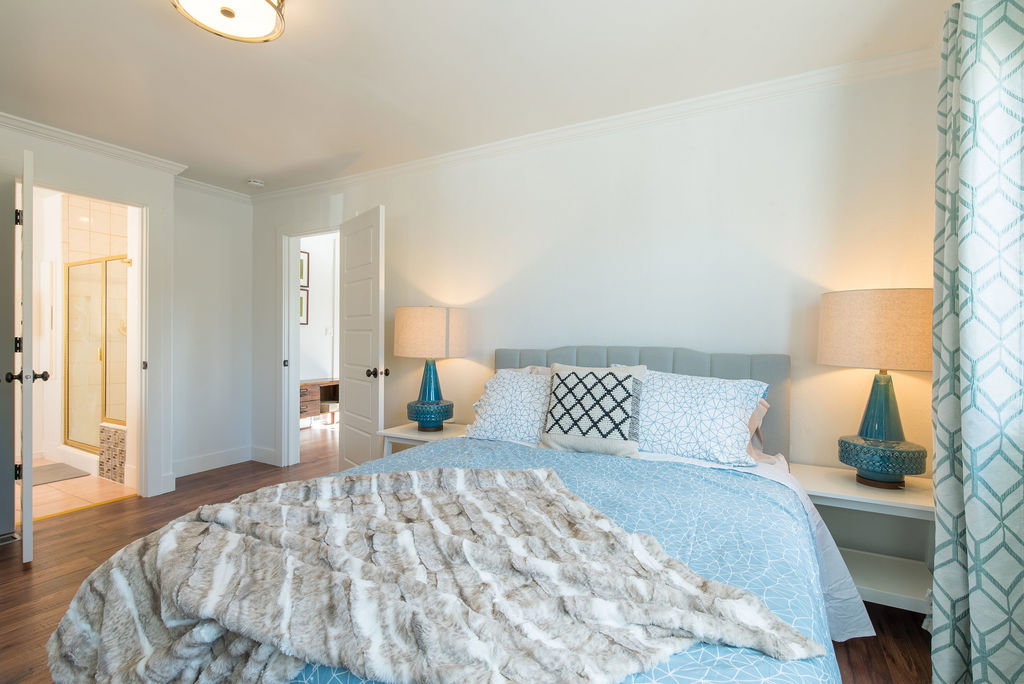 Bright interior space featuring wood-finish flooring, white walls, and crown molding