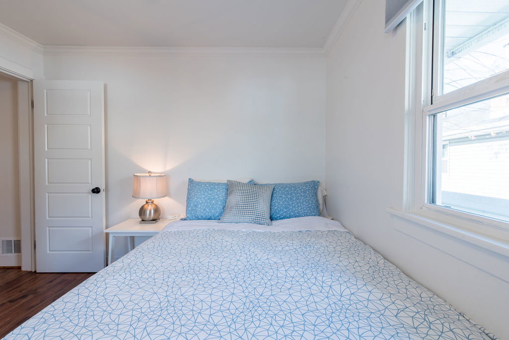 Bright room with wood-finish flooring and a multi-panel interior door