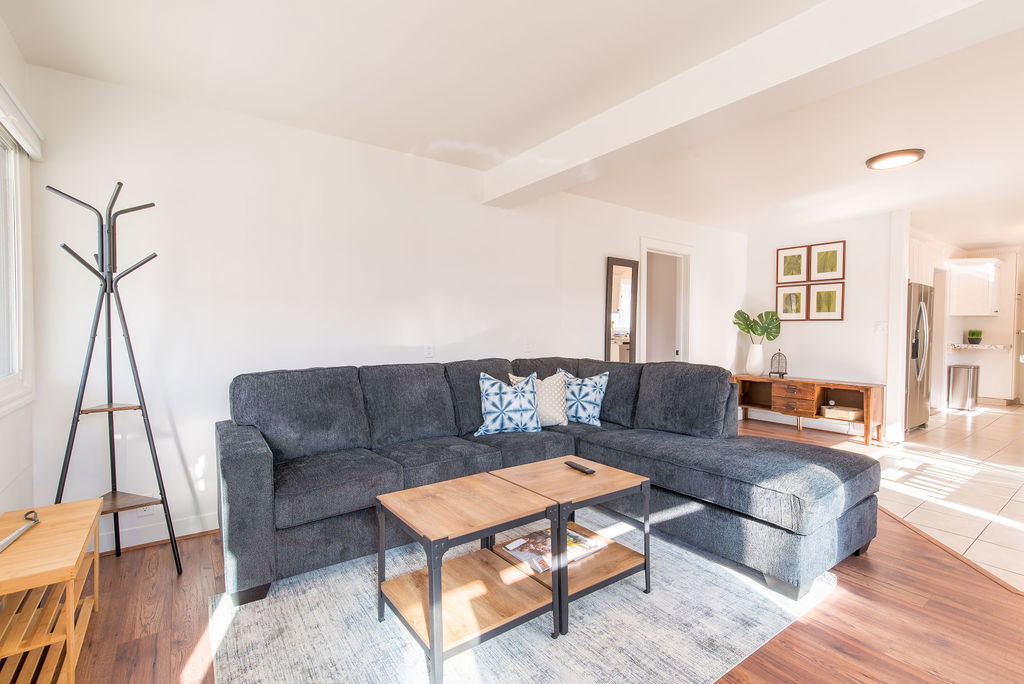 Spacious living area featuring wood-finish flooring, light neutral wall tones, and recessed lighting
