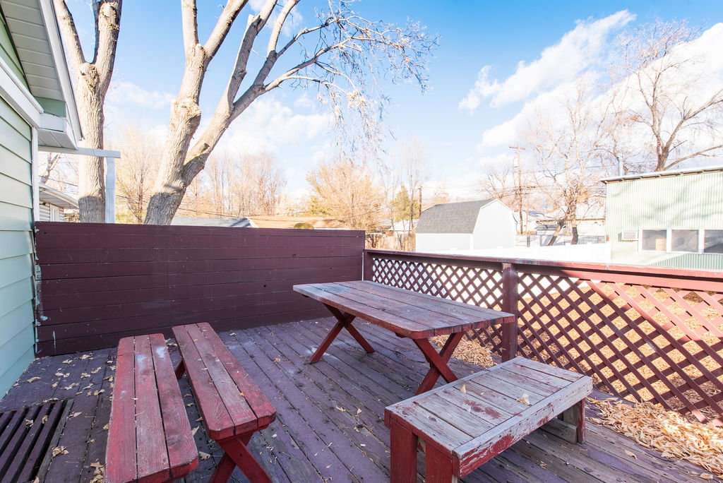 Wood-finish deck featuring a lattice railing, privacy fencing, and ample outdoor space