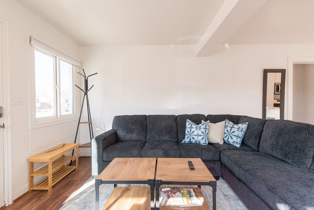 Living area featuring wood-finish flooring, white walls, and a large window