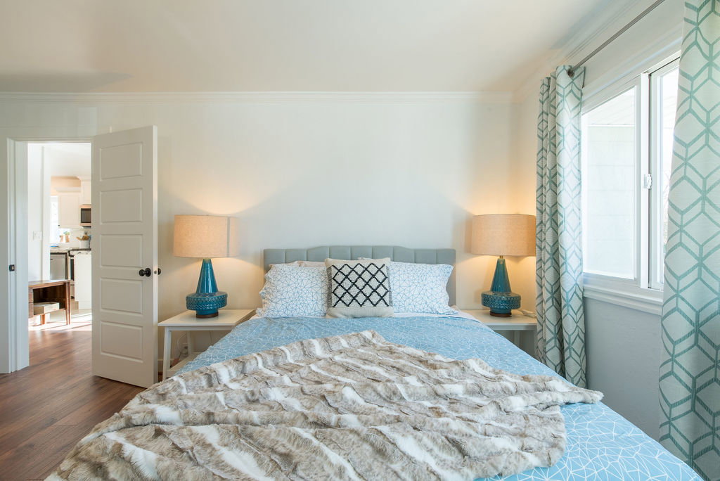 Room featuring wood-finish flooring, a neutral wall color, and white trim