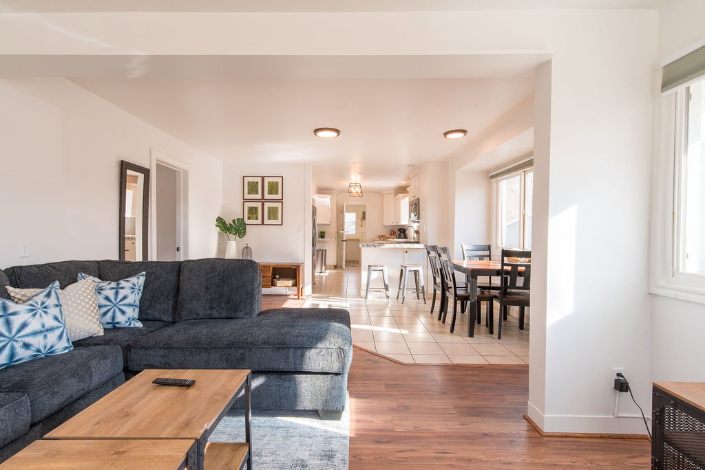 Open-concept living area with wood-finish flooring extending into the foreground
