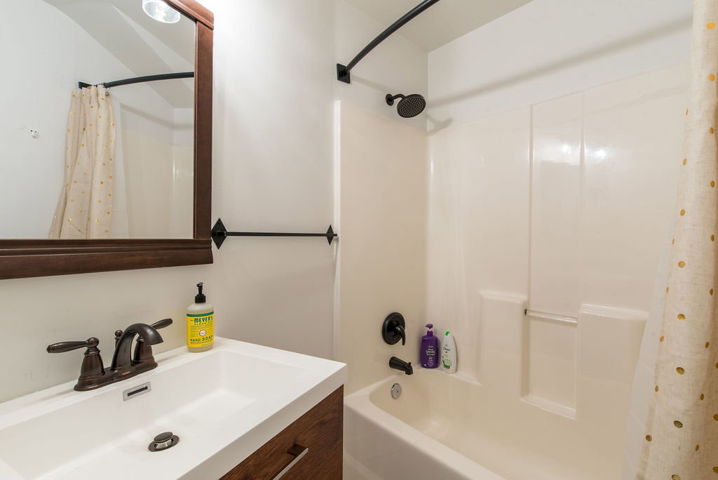 Bathroom featuring a white integrated sink and vanity with wood-finish cabinetry