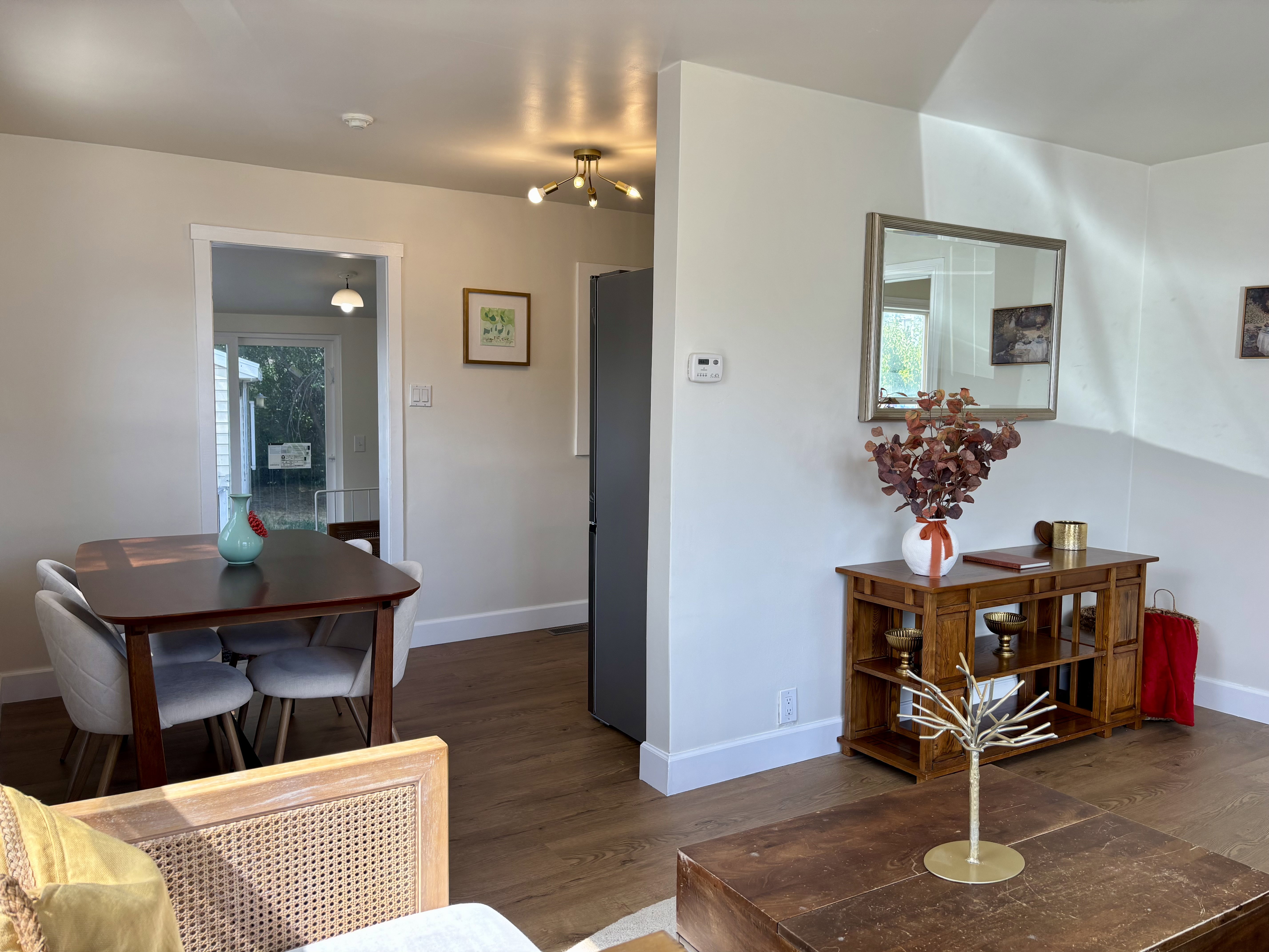 Open concept living space featuring wood-finish flooring, neutral wall tones, and a modern ceiling light fixture