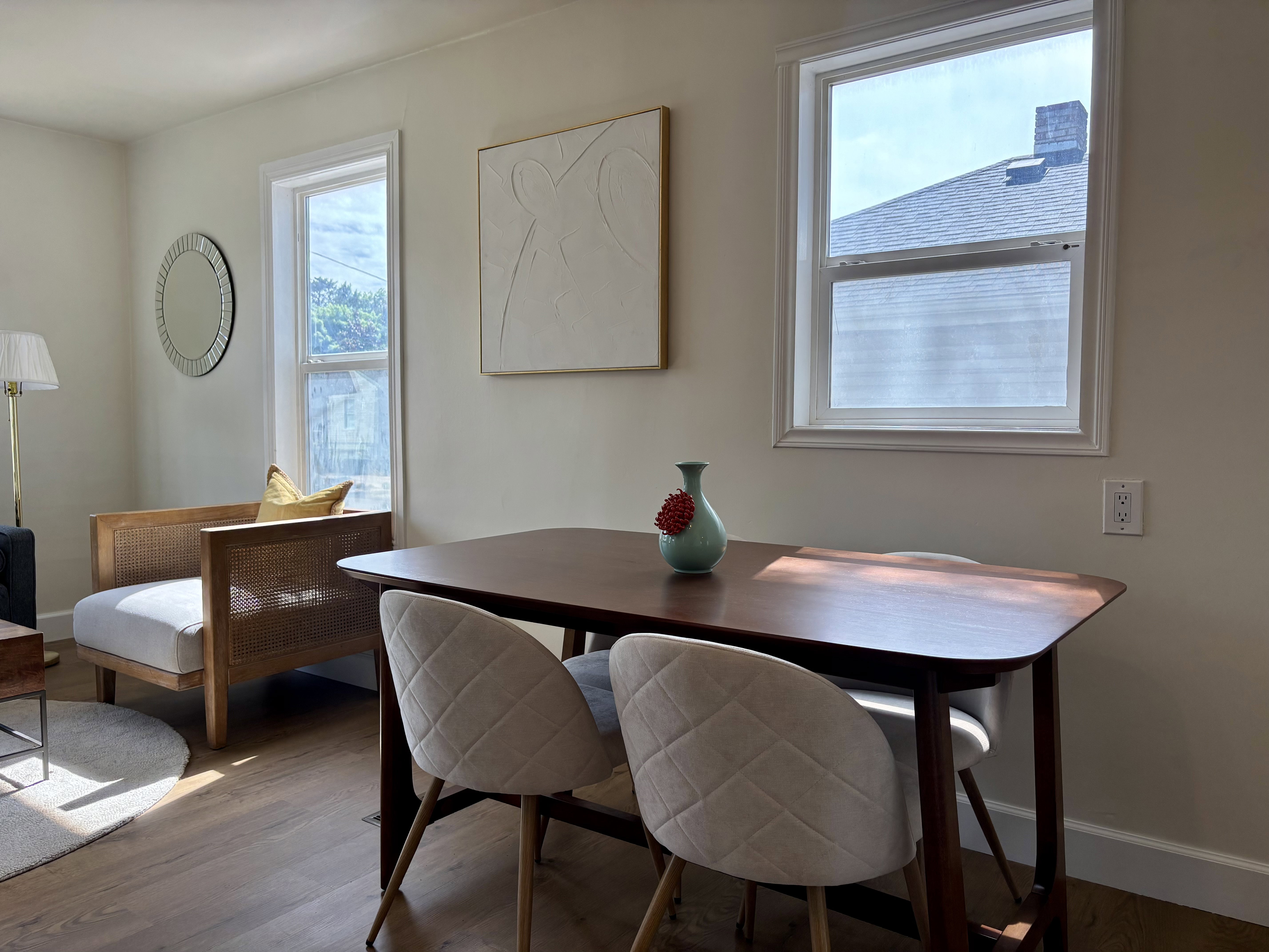 Warm-toned wood-finish flooring complements the light-colored walls in this interior space