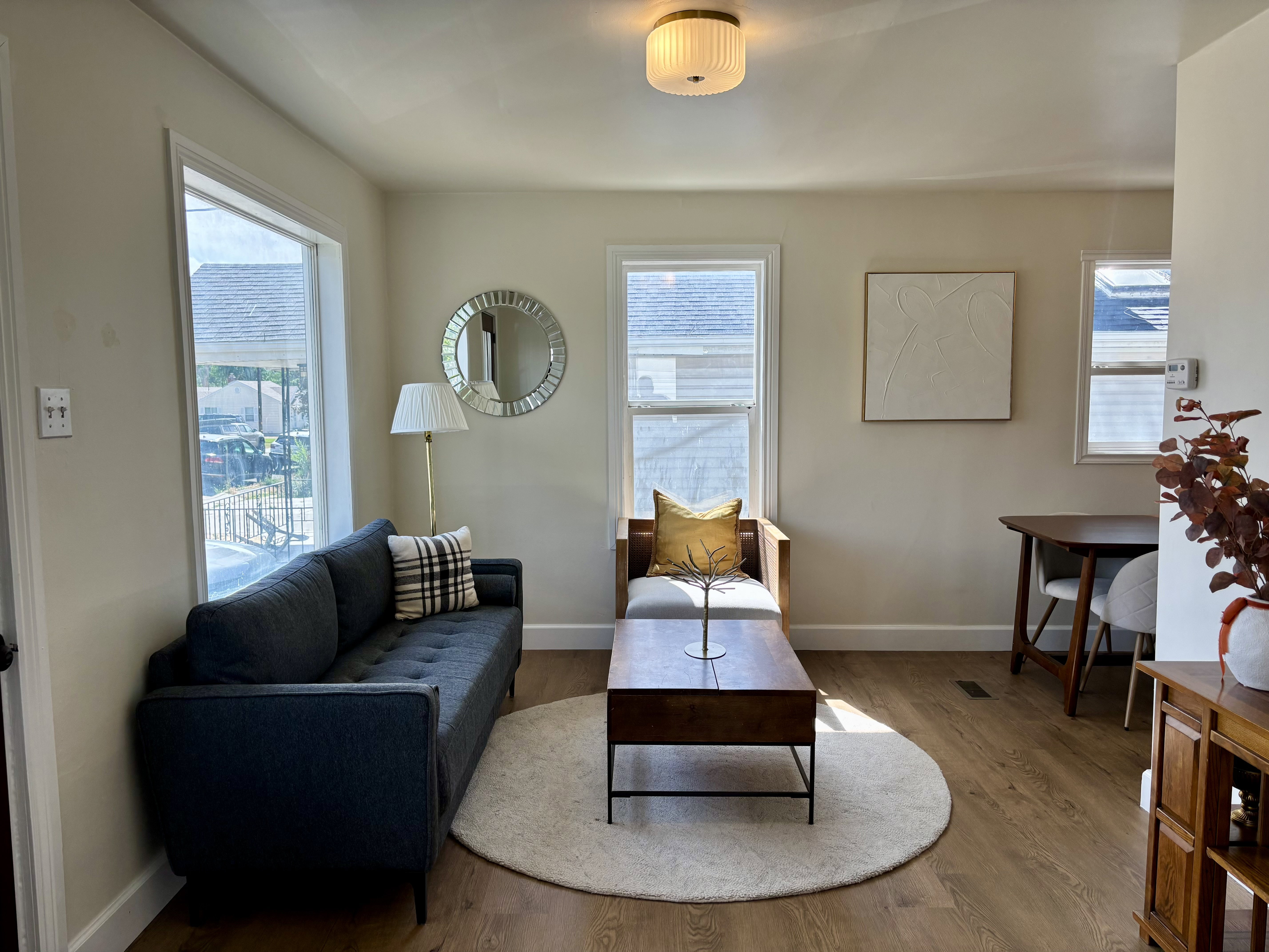 Living space featuring wood-finish flooring, neutral wall tones, and multiple windows
