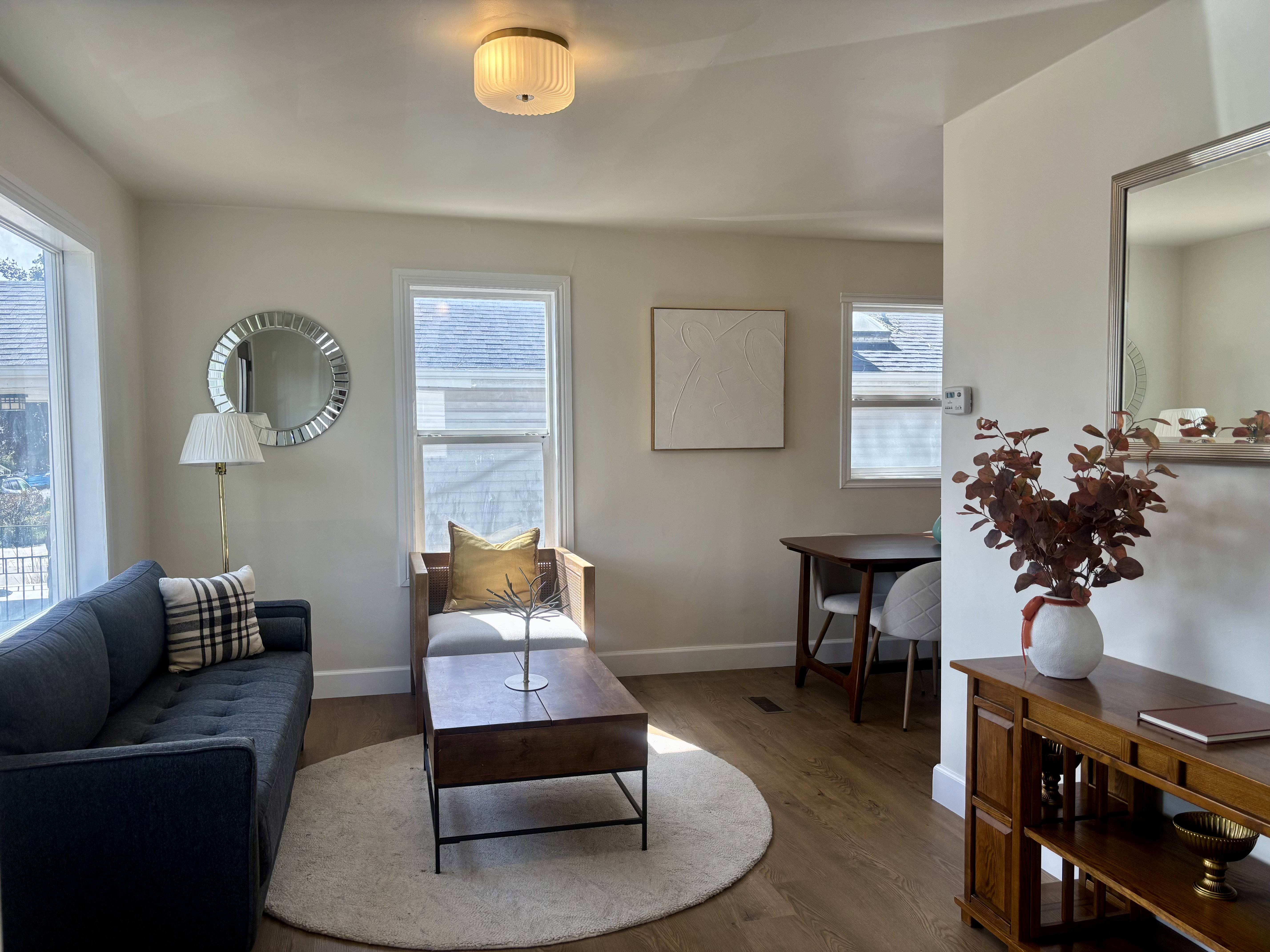 Living area featuring wood-finish flooring, light-toned walls, and multiple windows