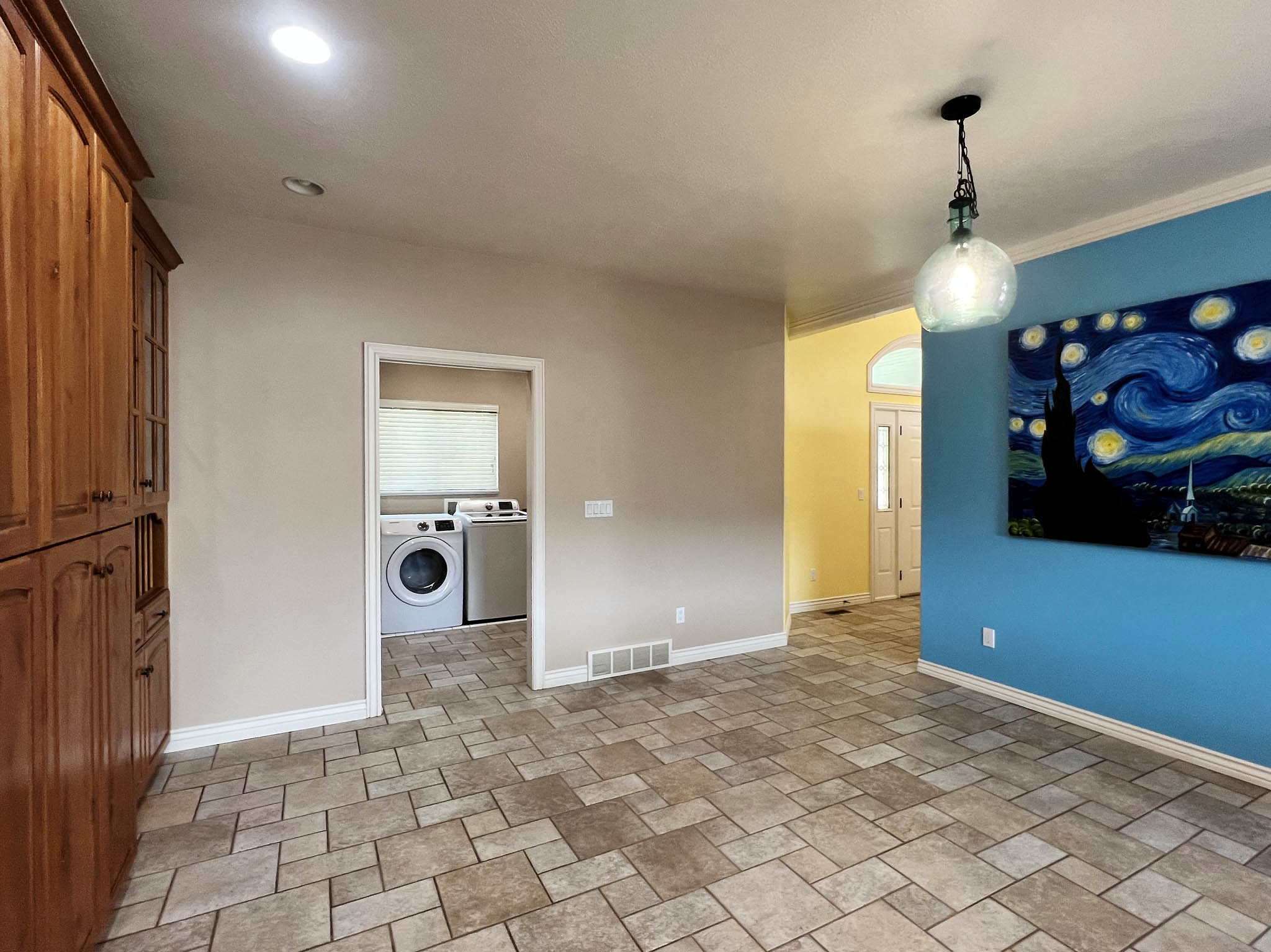 Spacious room featuring patterned tile flooring, wood-finish cabinetry, and recessed lighting