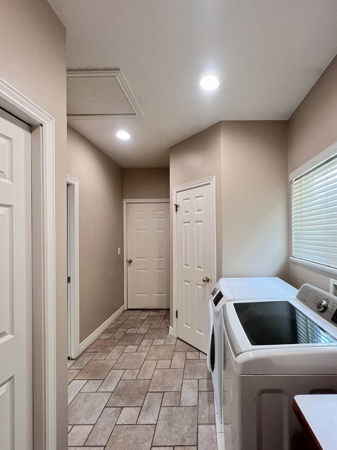 Laundry area featuring ceramic tile flooring, recessed lighting, and a window with blinds