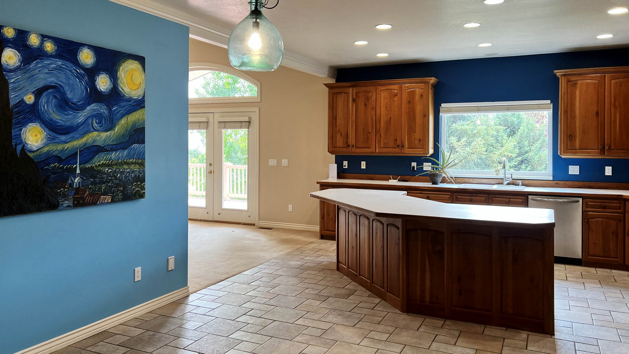 Spacious kitchen featuring an angular island with integrated seating, extensive wood cabinetry, and recessed lighting