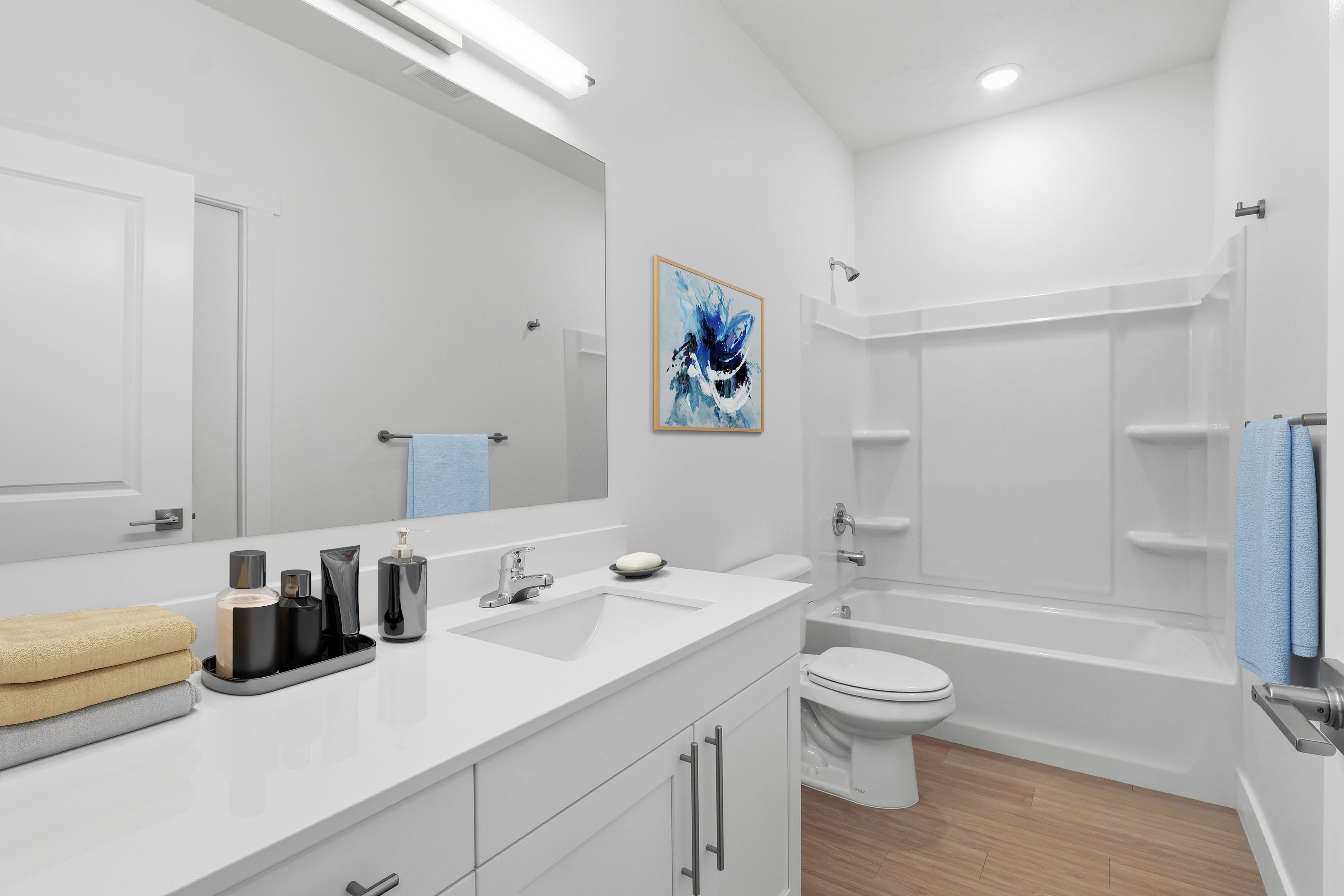 Bathroom featuring a white vanity with integrated sink, chrome faucet, and expansive wall-mounted mirror