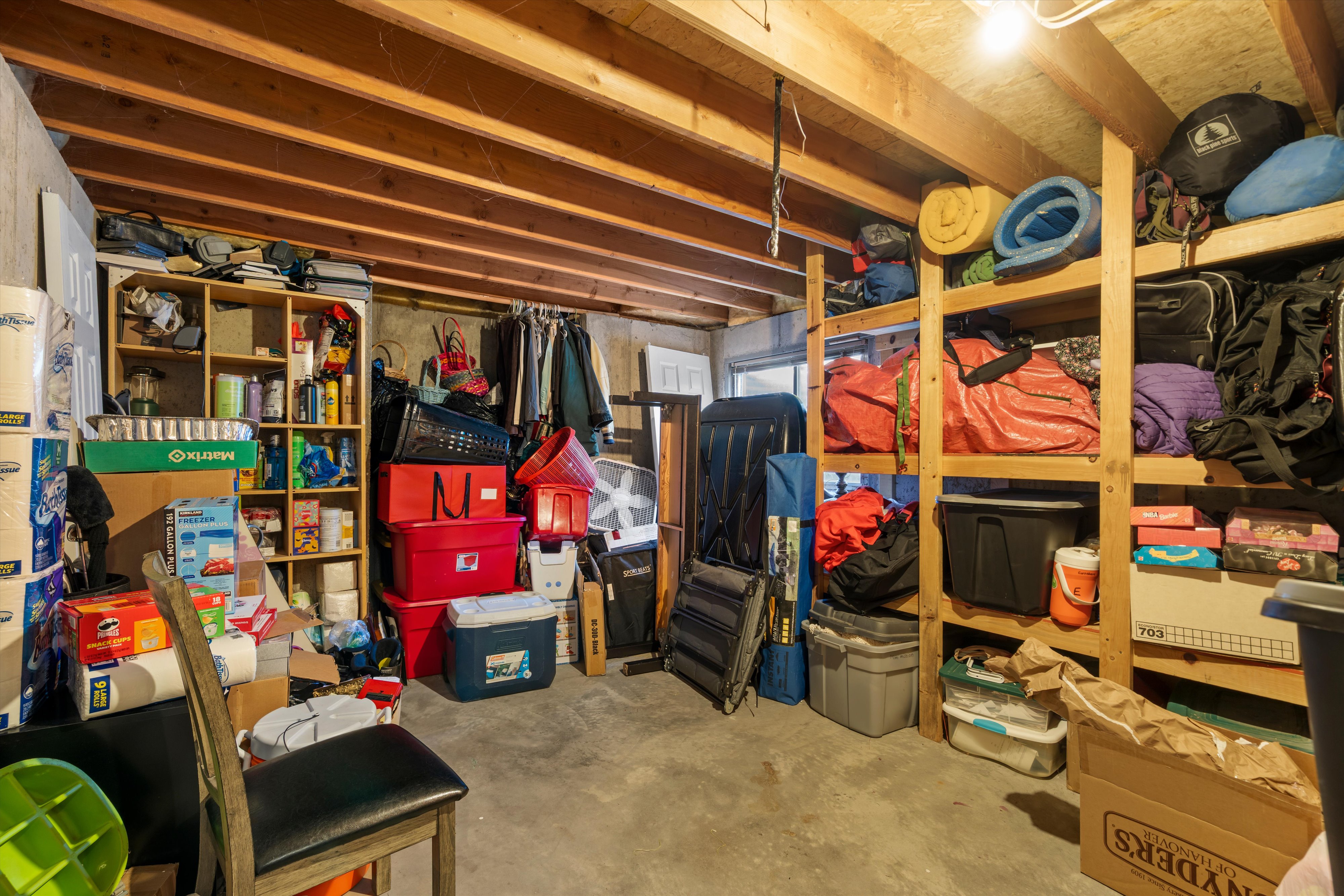 Unfinished basement space featuring exposed wood joists and concrete flooring