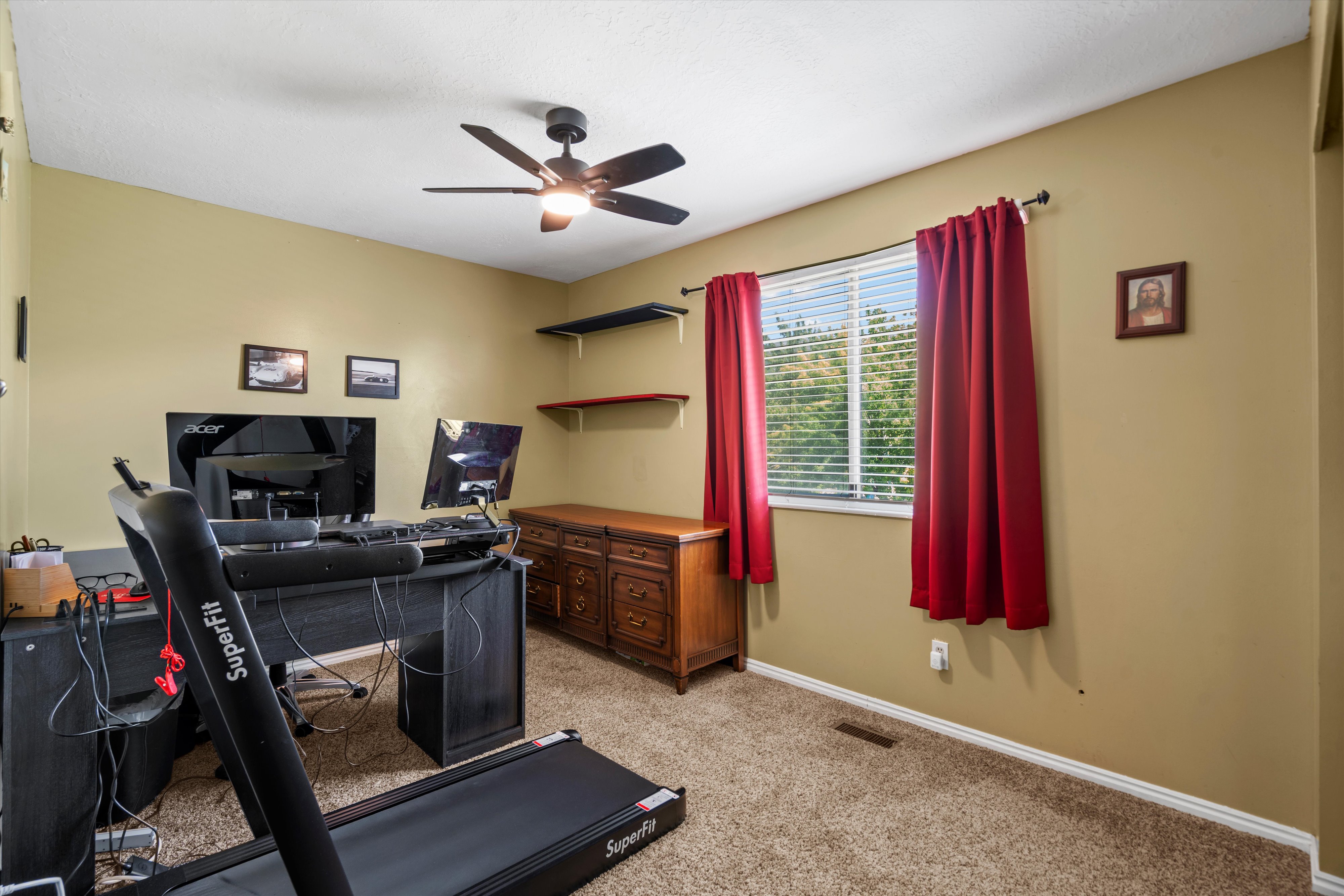 Room featuring a window with white blinds, a ceiling fan with light fixture, and carpet flooring