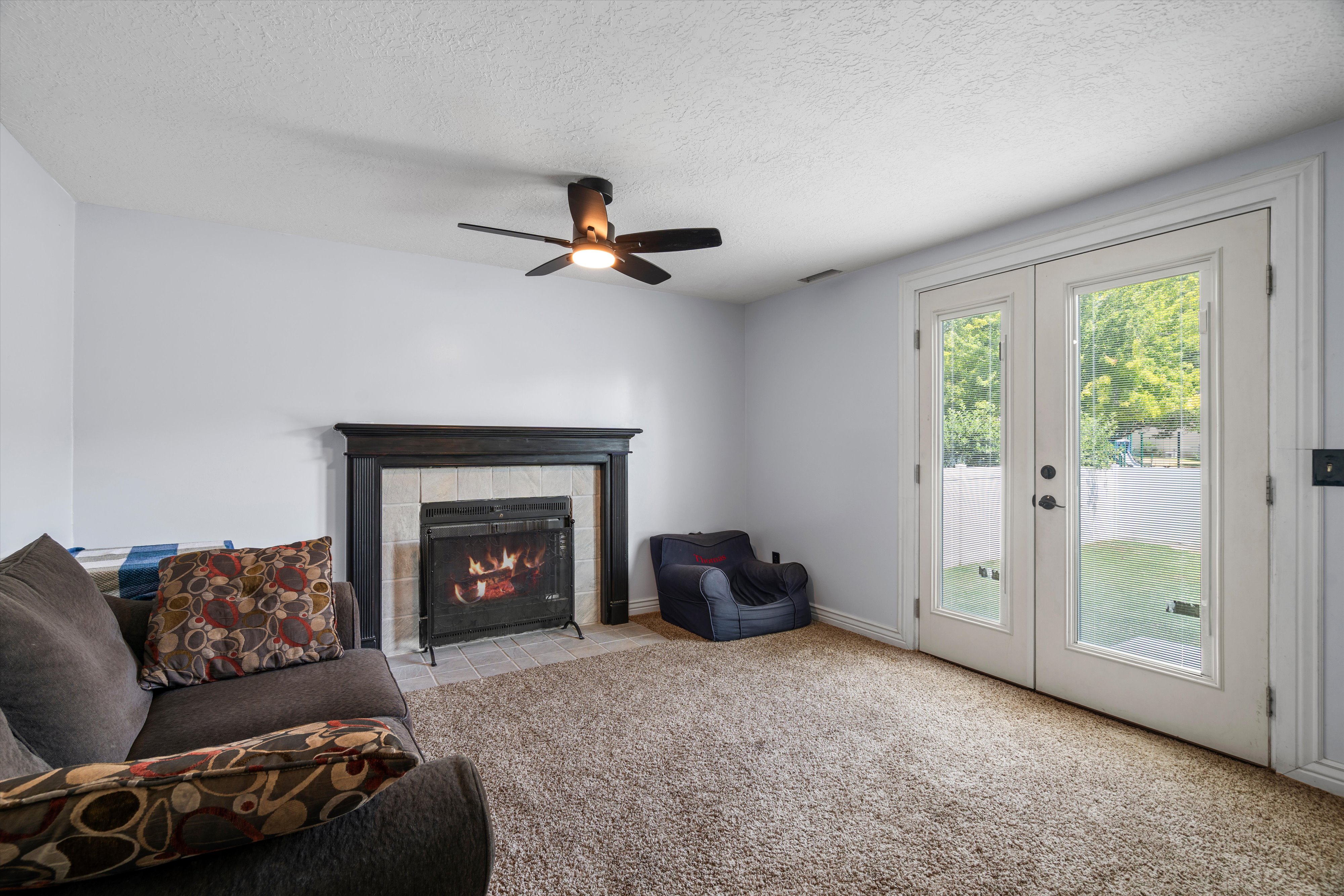 Living area featuring a fireplace with a dark wood-finish mantel and tile surround