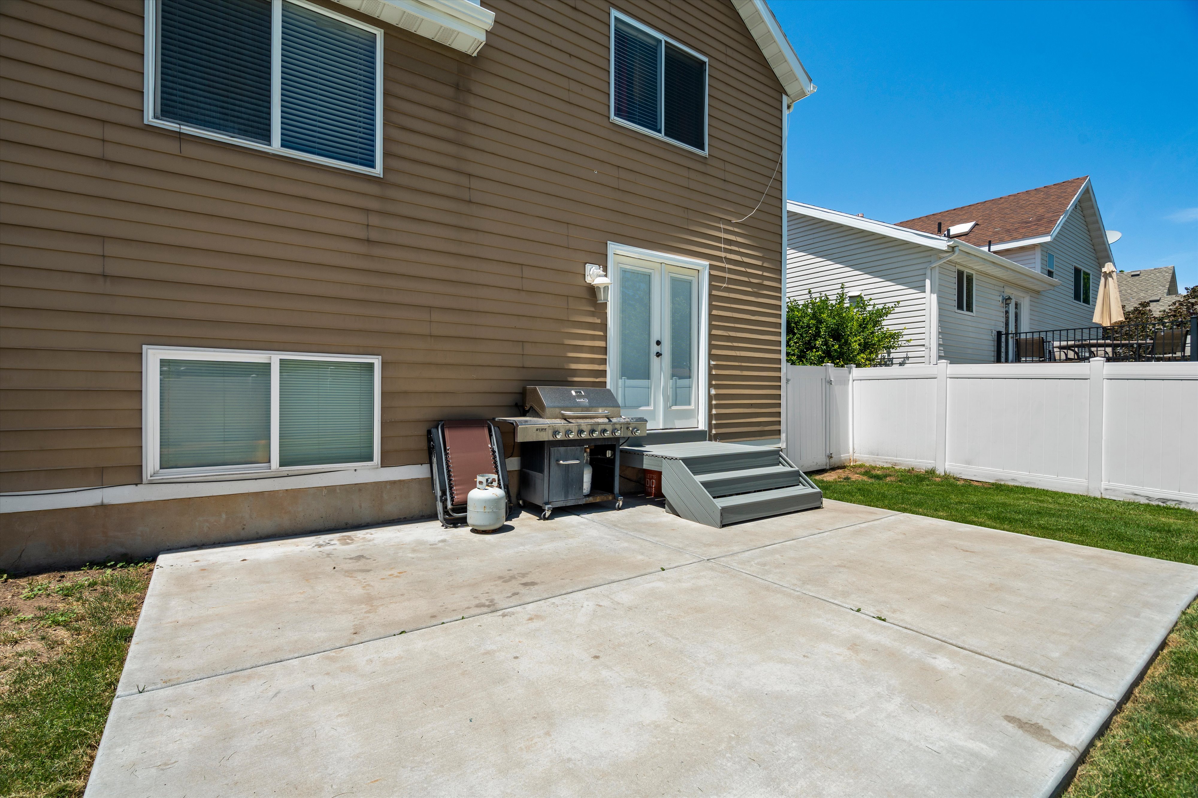 Expansive concrete patio with direct outdoor access via double doors