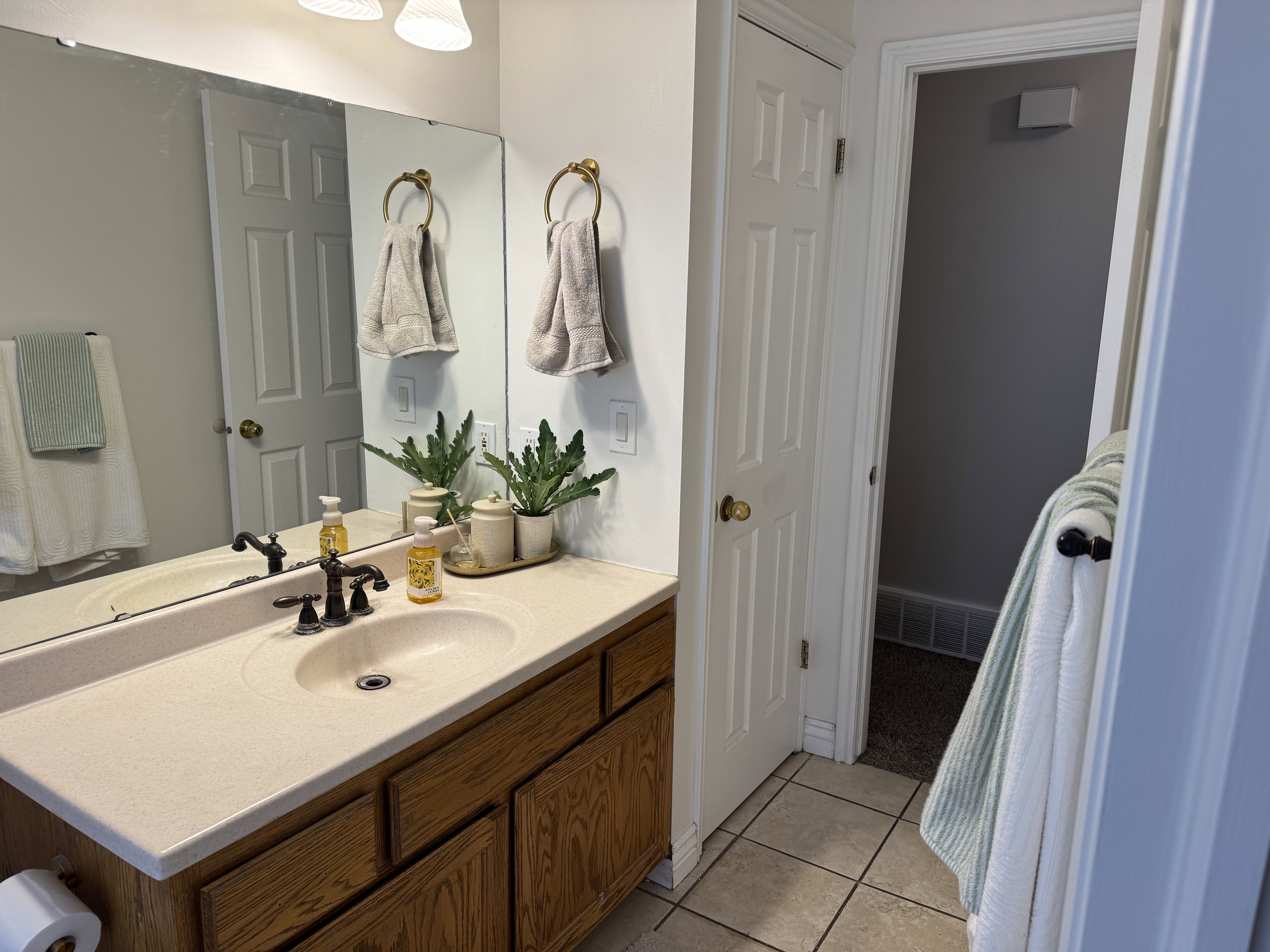Bathroom featuring a single vanity with wood-finish cabinetry and an integrated sink