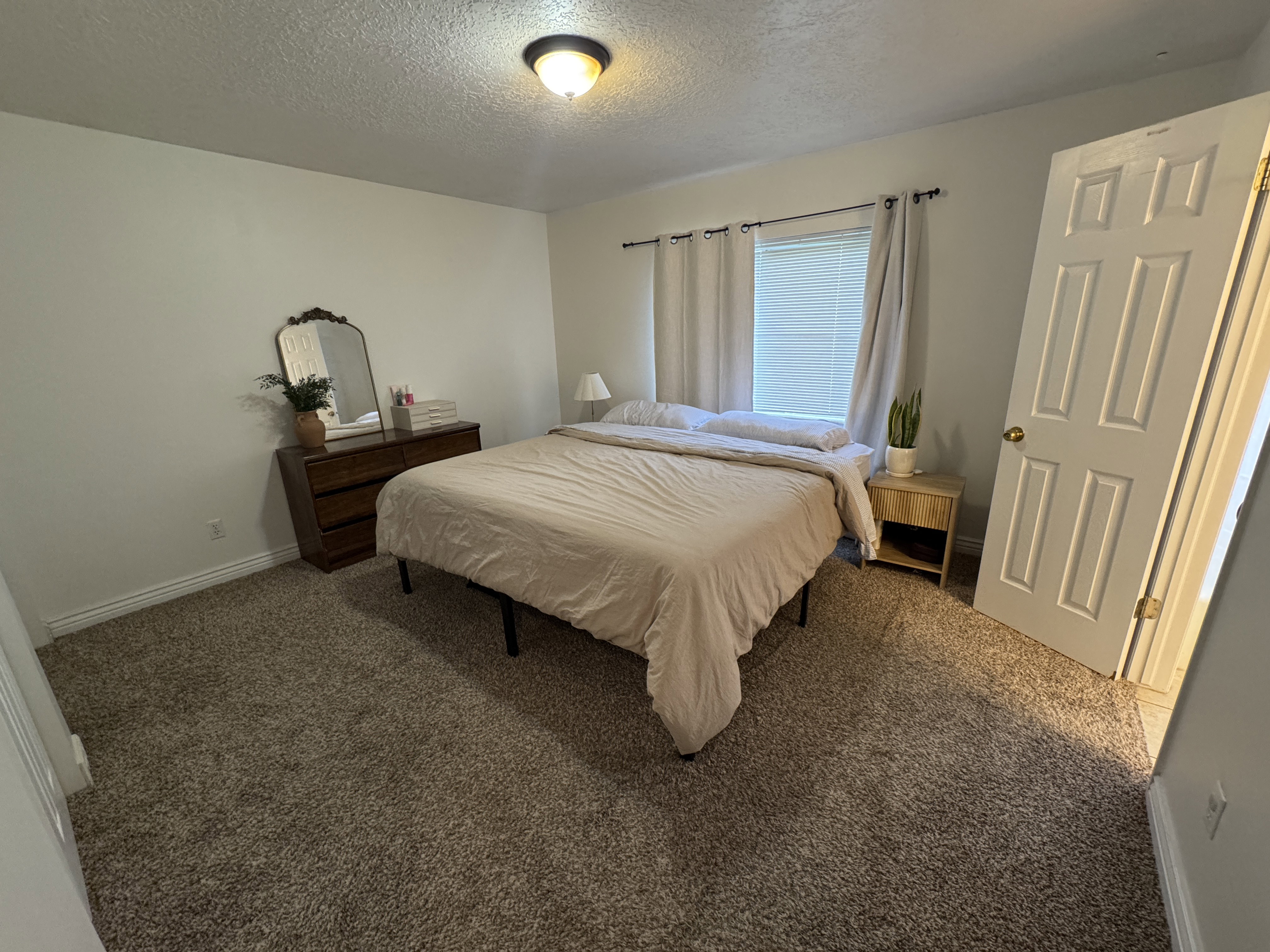 Neutral wall color with a window featuring blinds and drapes