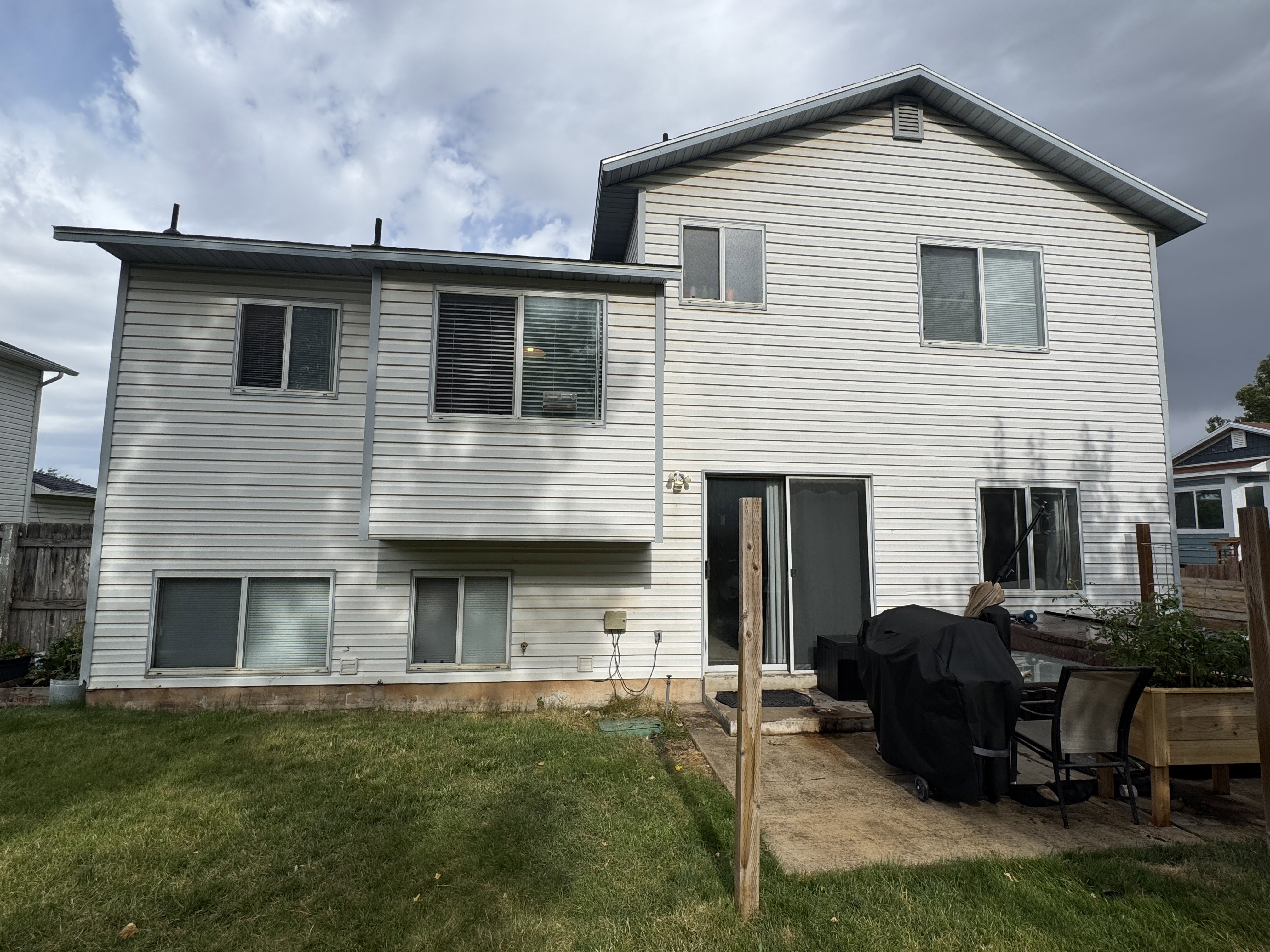 Rear exterior featuring white vinyl siding and multiple windows across two levels