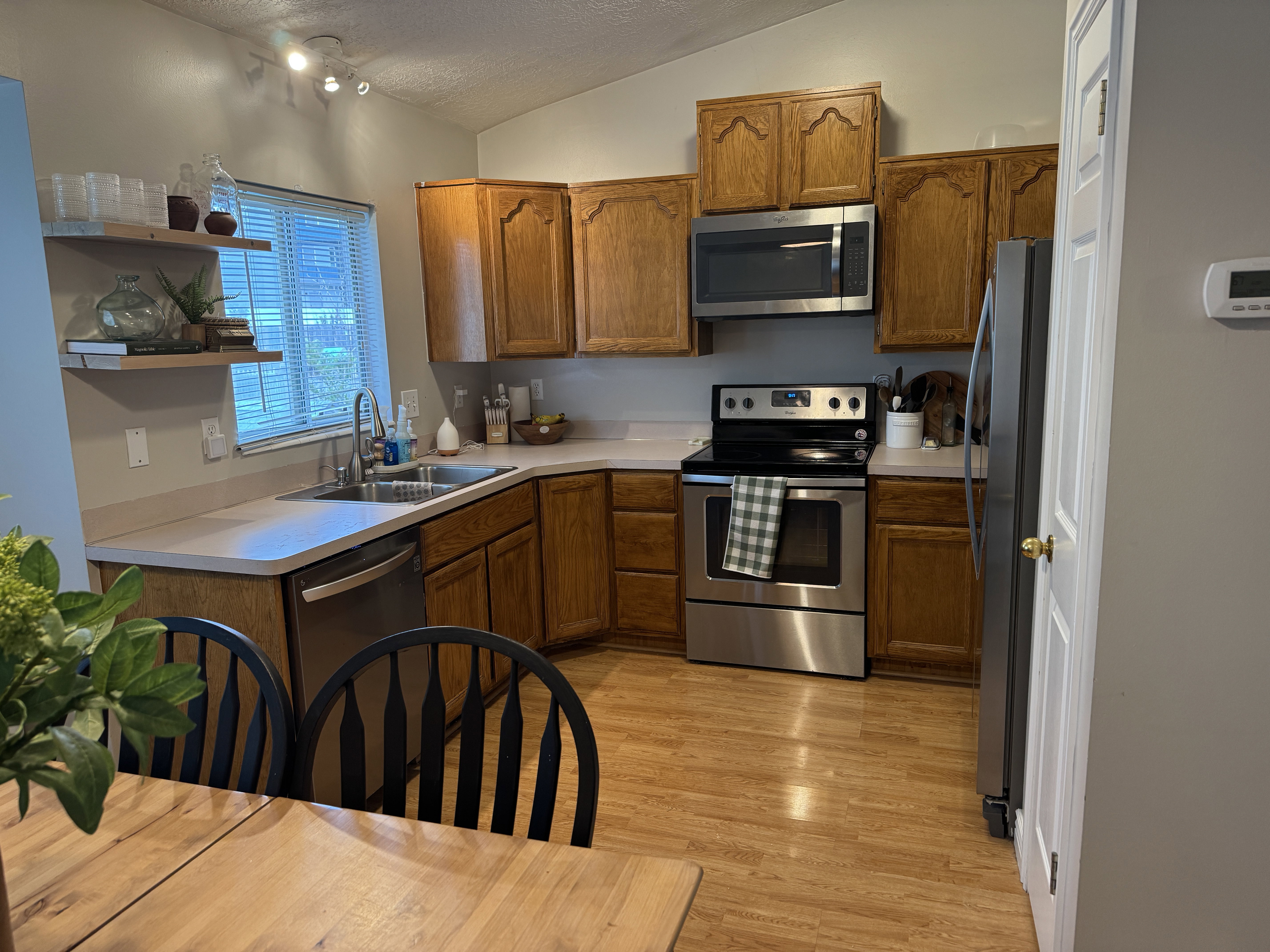 Kitchen featuring wood cabinetry, light-toned countertops, and stainless steel appliances