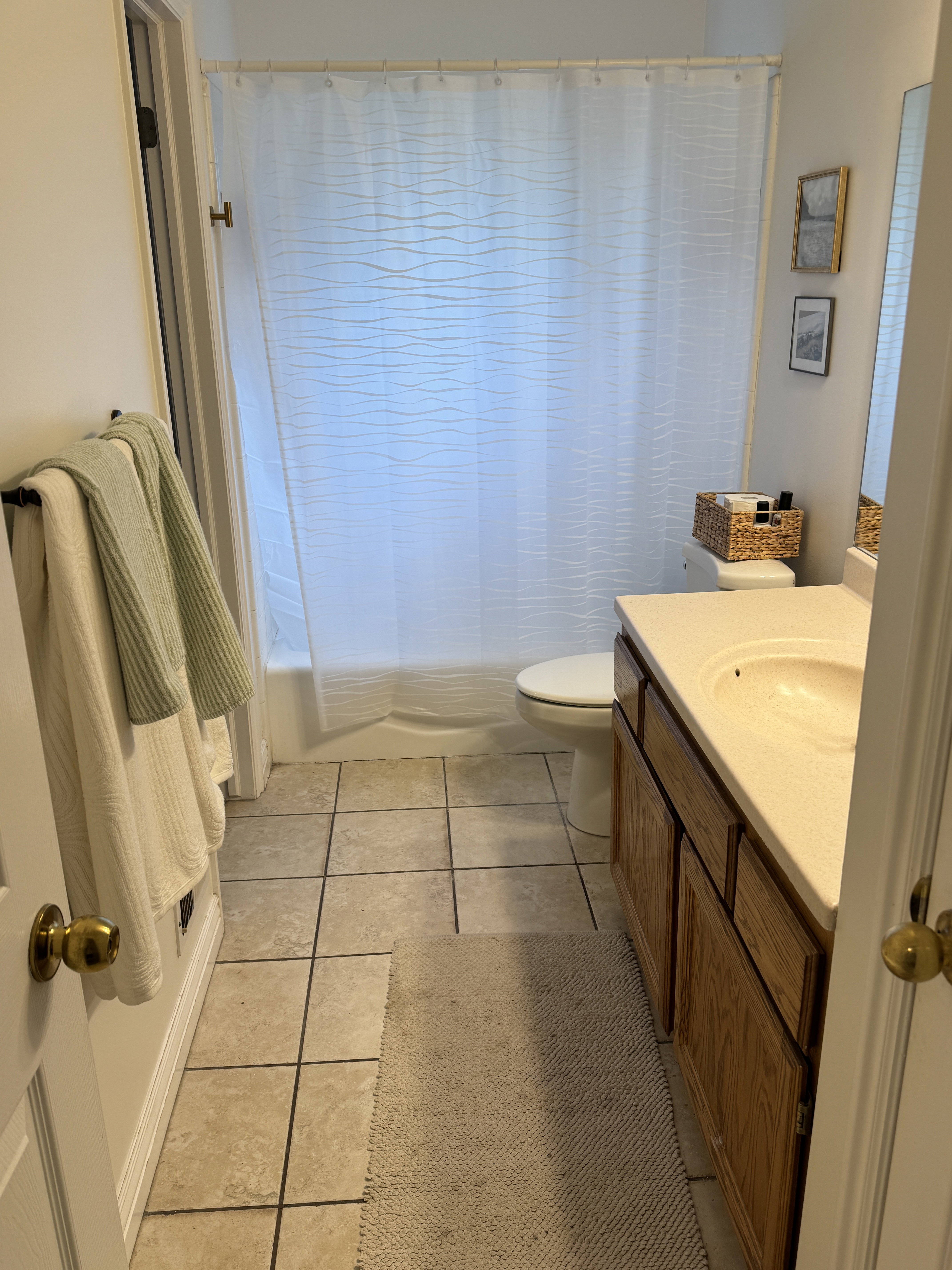 Full bathroom featuring a single vanity with a solid surface countertop, an integrated sink, and wood-finish cabinetry
