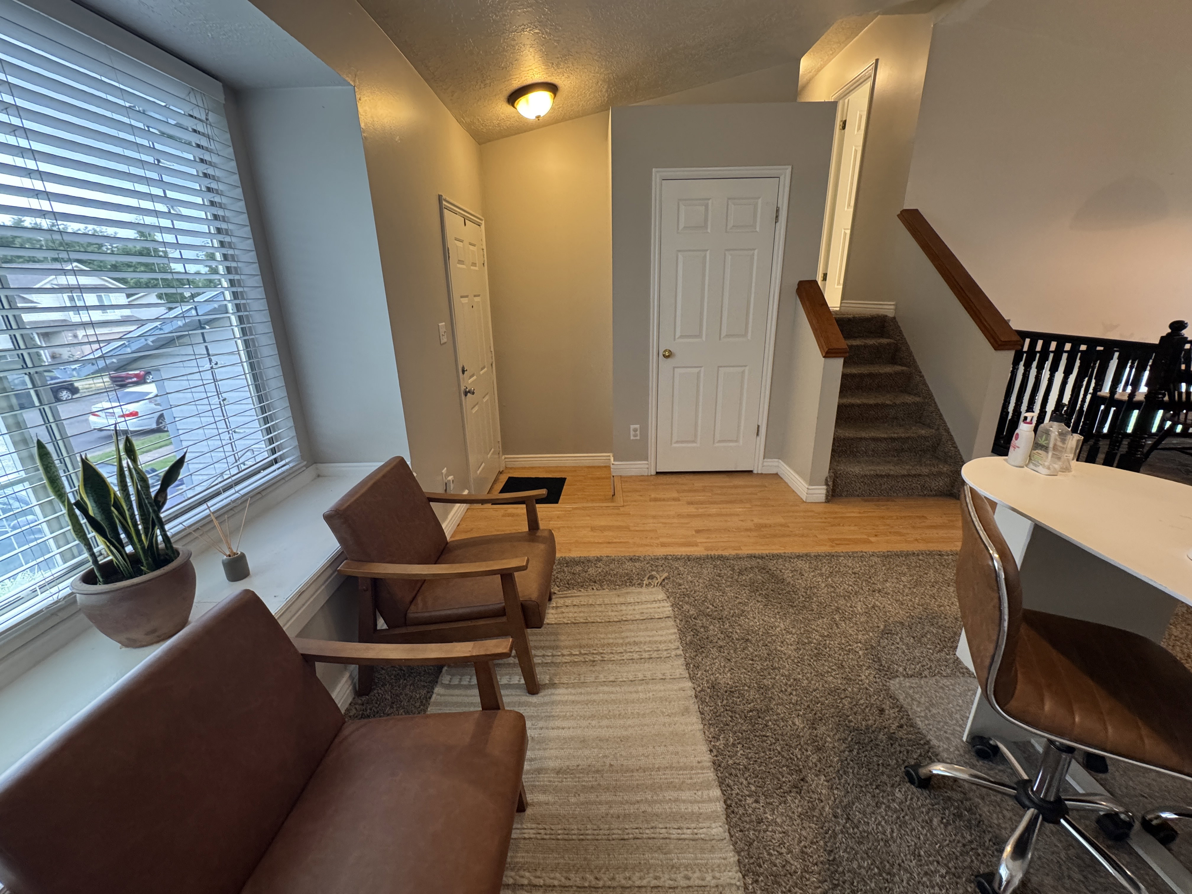 Entryway featuring hardwood flooring, a multi-panel door, and a carpeted staircase with wood handrails