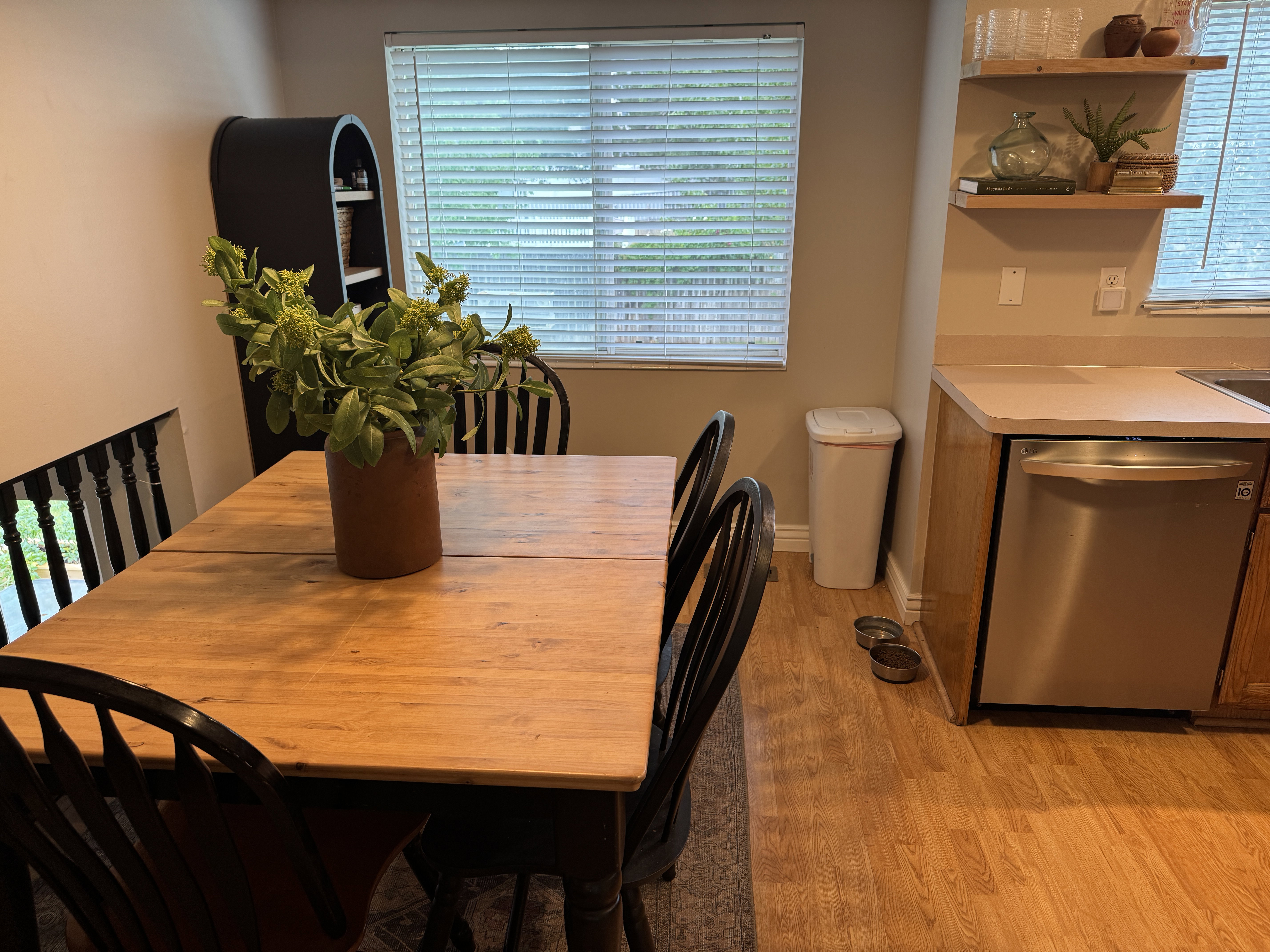 Dining area featuring a wood-finish table, a built-in shelving unit, and wood-finish flooring