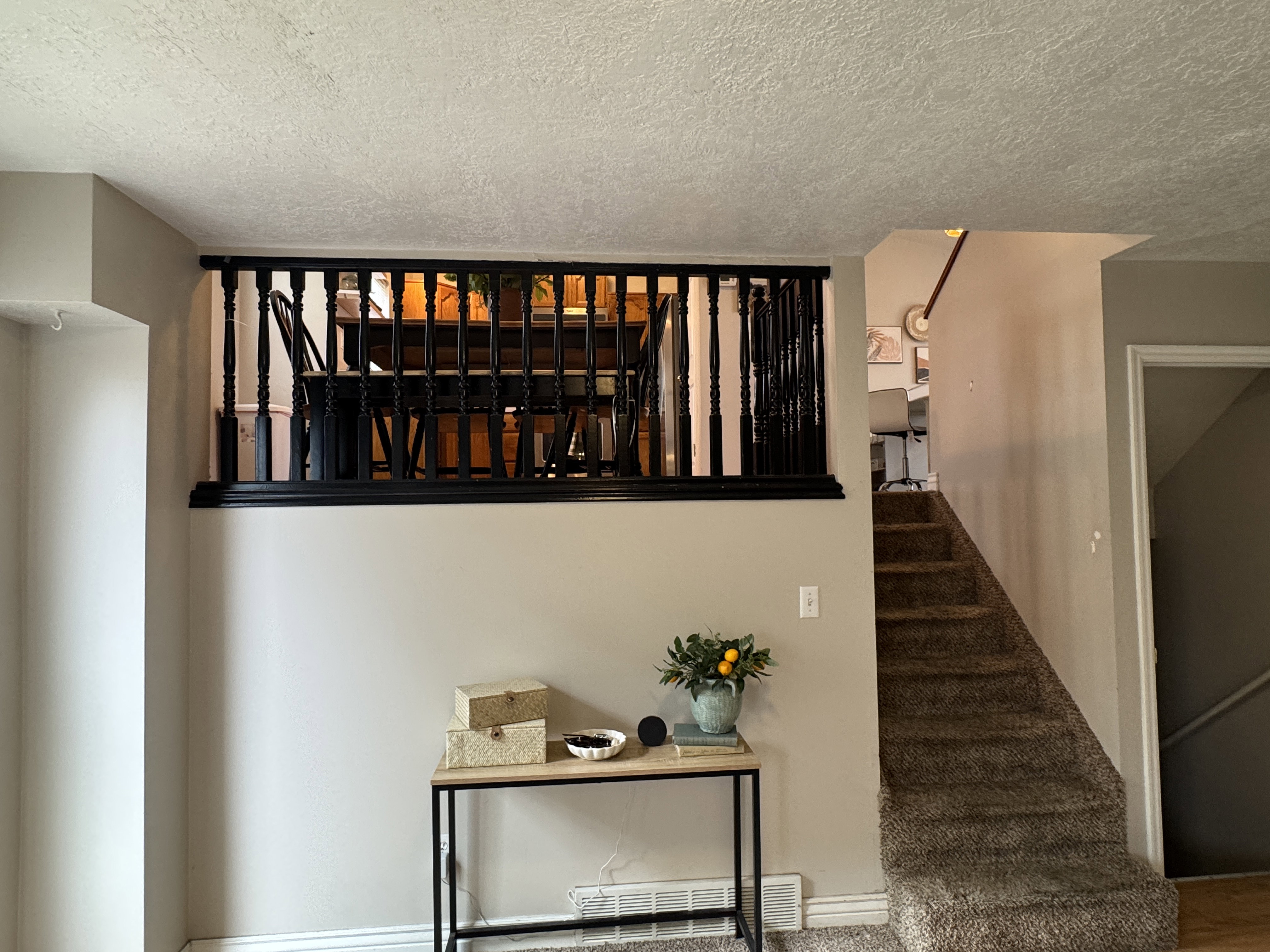 Carpeted staircase leading to an upper level, featuring light neutral wall paint and white baseboards