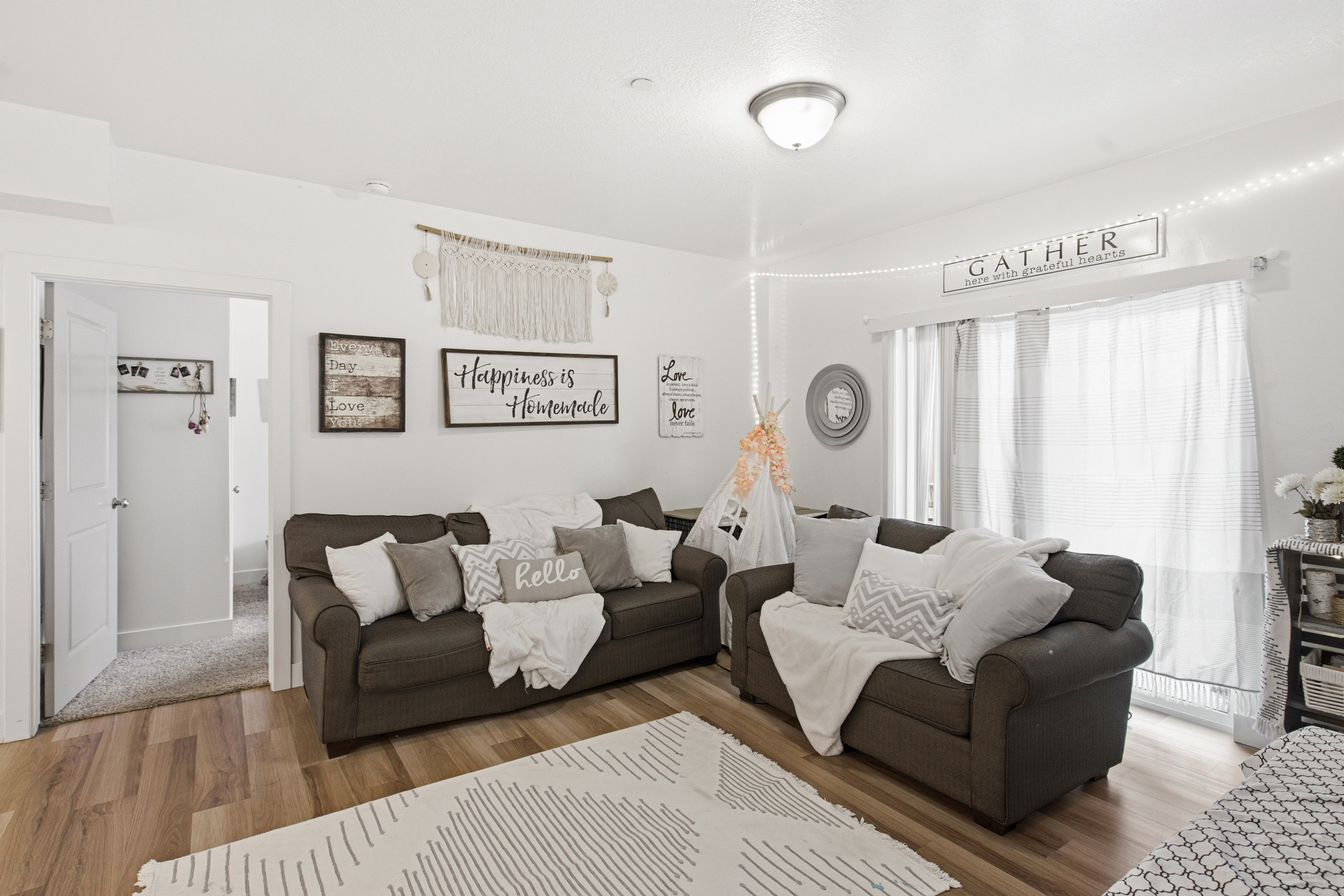 Spacious living area featuring wood-finish flooring, white walls, and a recessed ceiling light