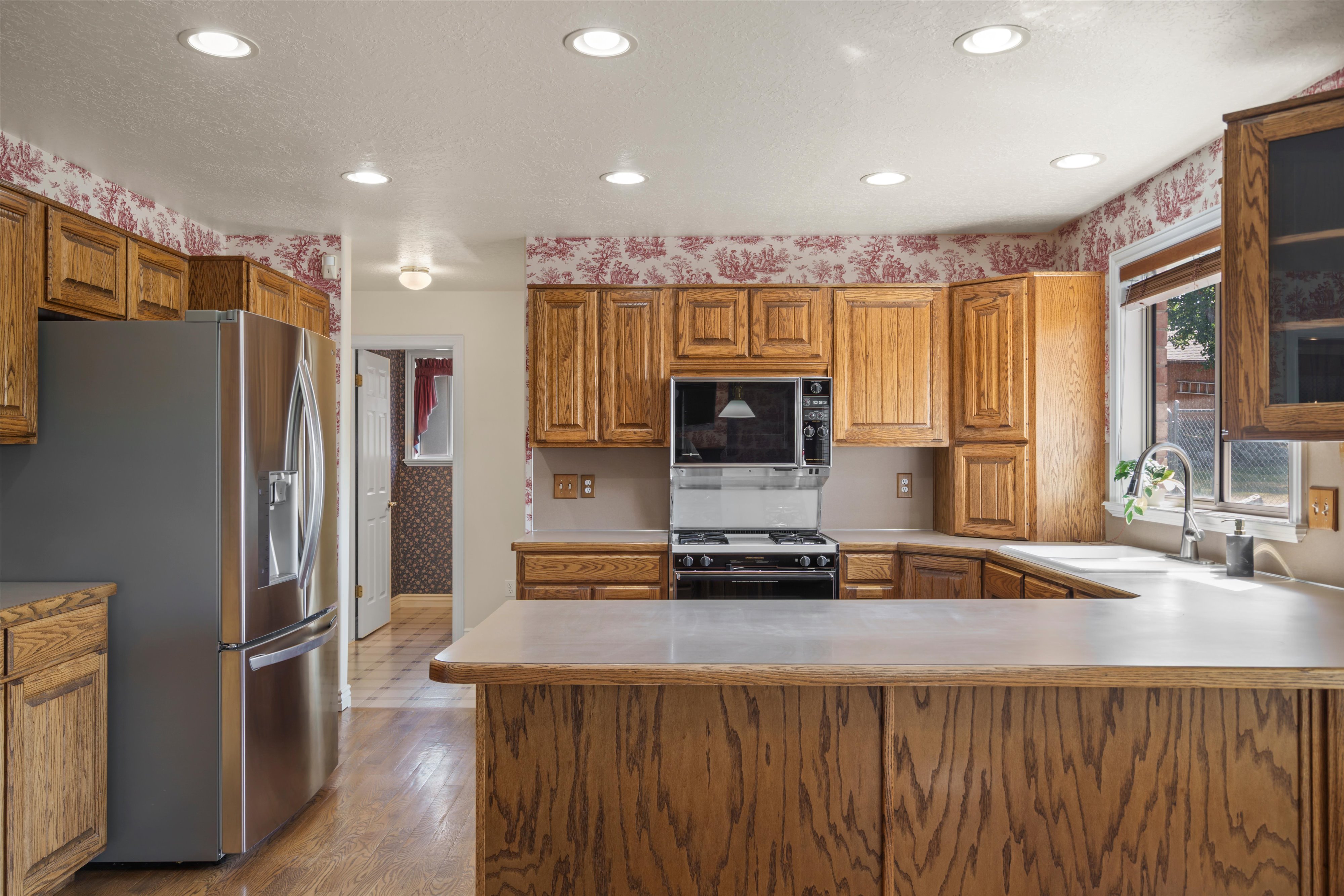 Kitchen featuring wood cabinetry, stainless steel appliances, a built-in microwave, a gas range, and recessed lighting