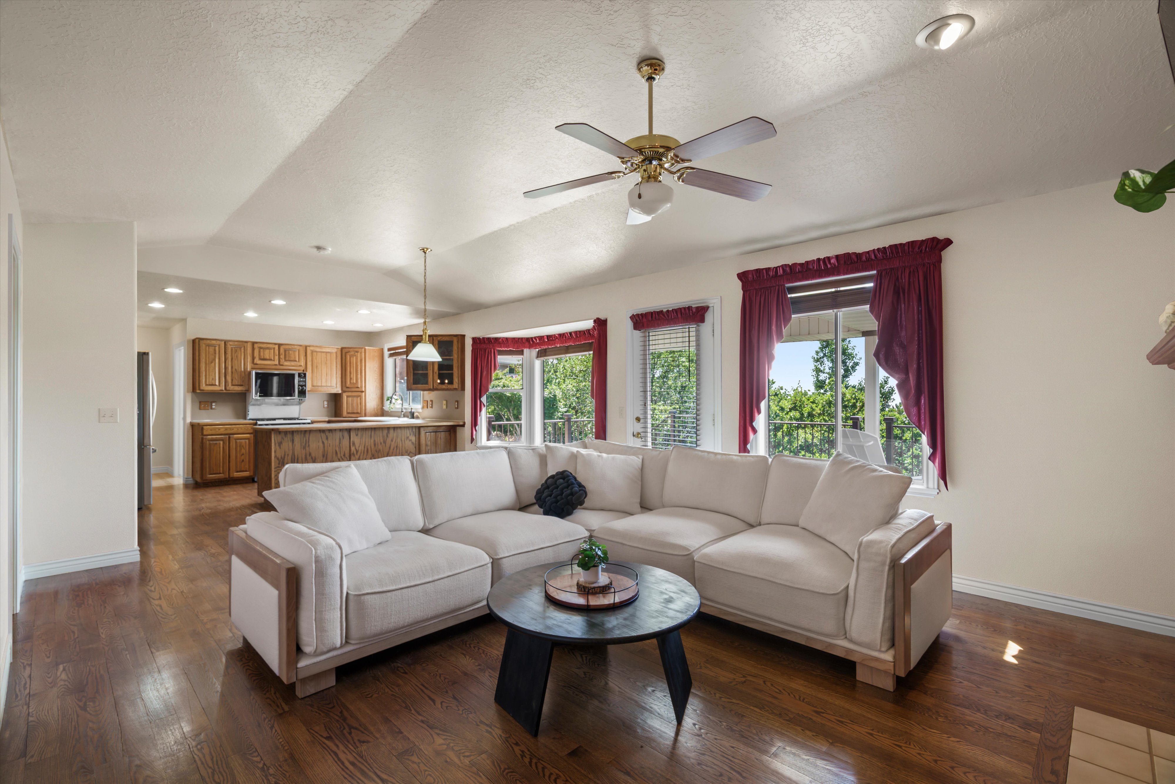 Open-concept living space featuring wood-finish flooring, vaulted ceiling, and recessed lighting