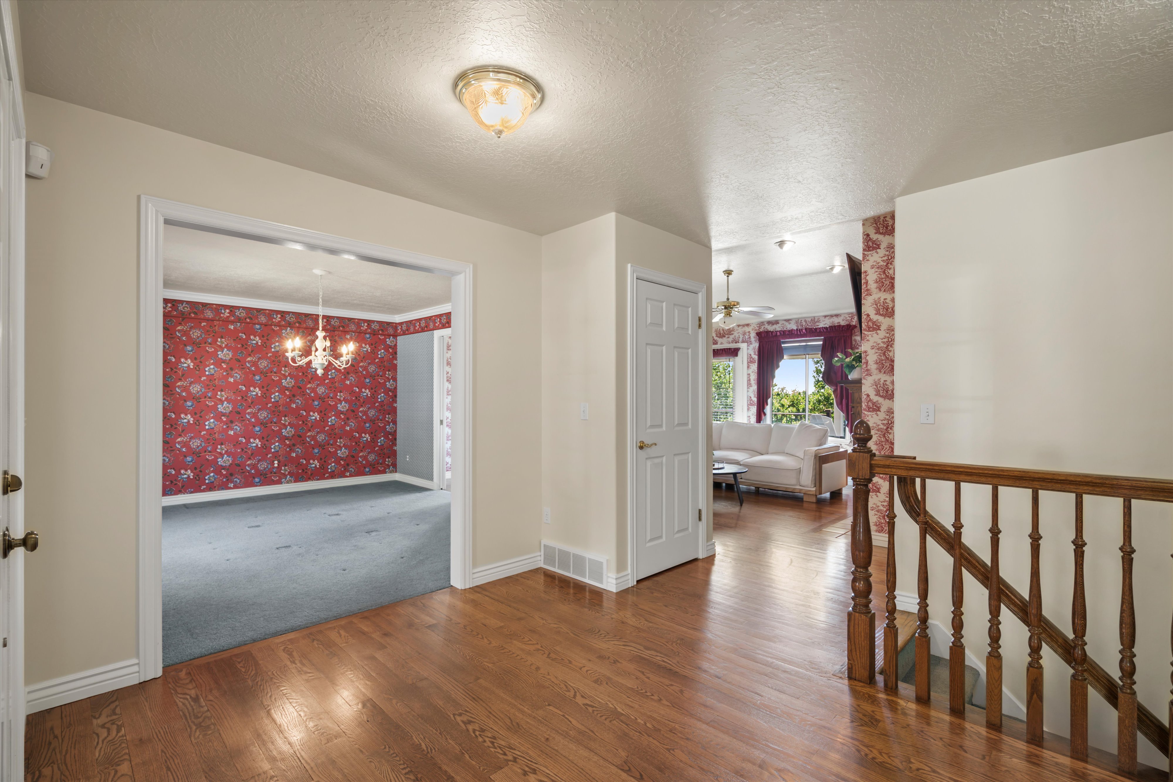 Entryway featuring wood-finish flooring, a decorative overhead light fixture, and a wooden stair railing