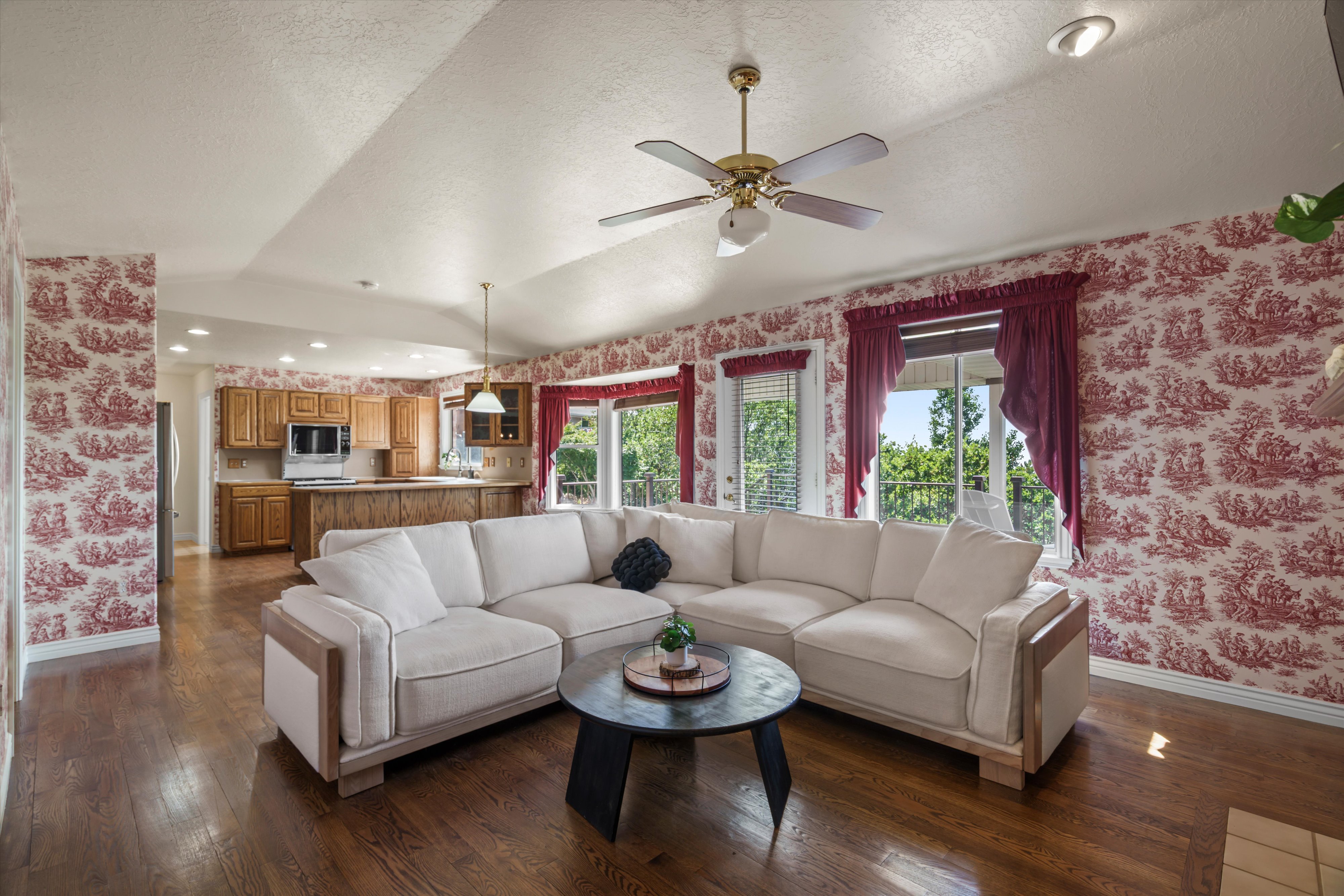 Open-concept living space featuring wood-finish flooring, vaulted ceilings with a ceiling fan, and recessed lighting