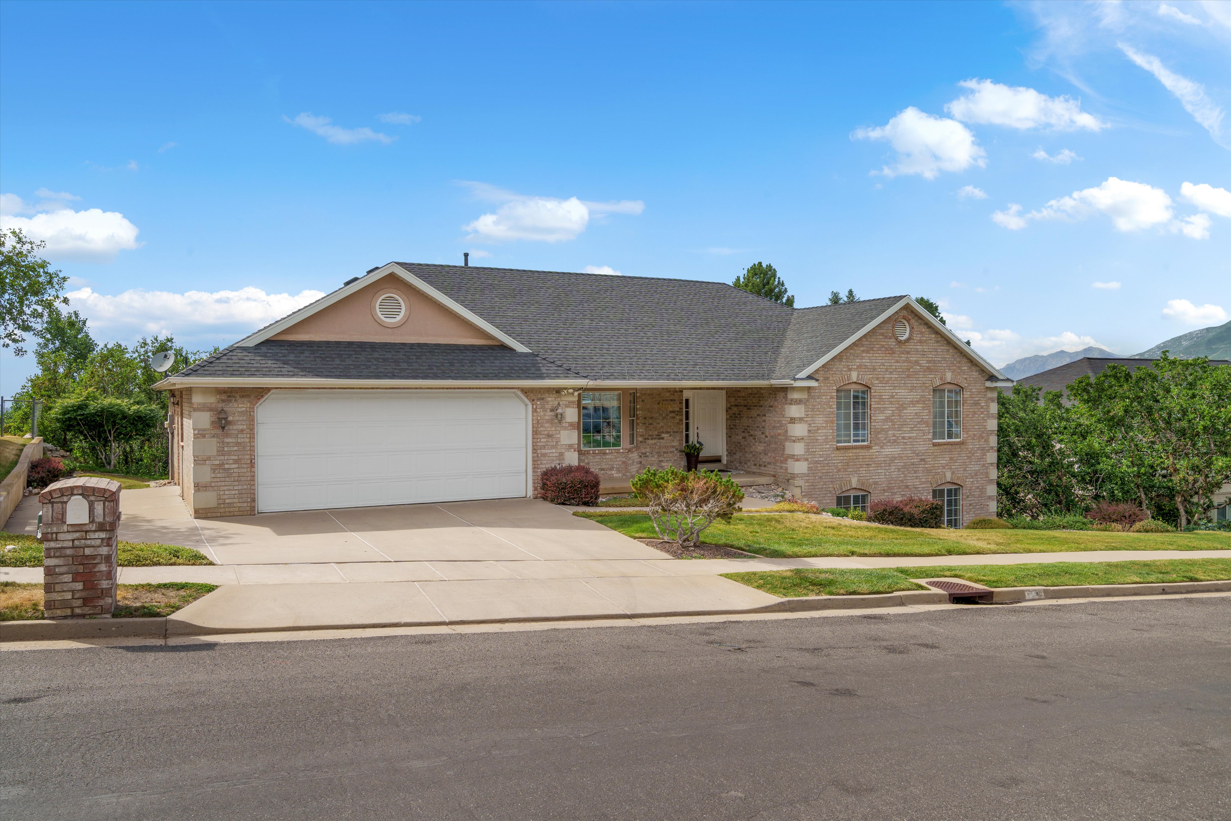 Brick and stone exterior with a dark shingle roof