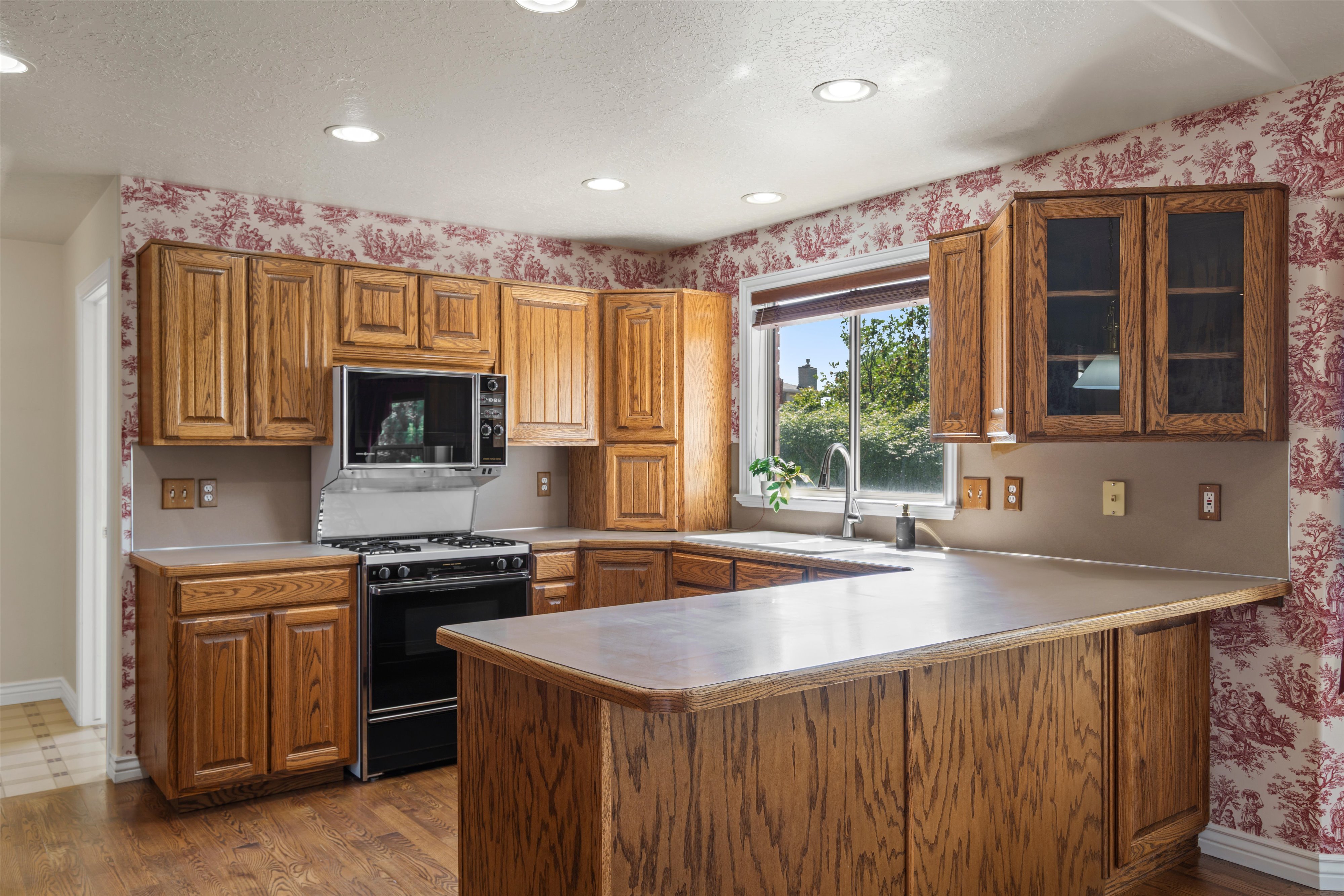 Kitchen featuring wood cabinetry, recessed lighting, and a built-in oven with a gas range