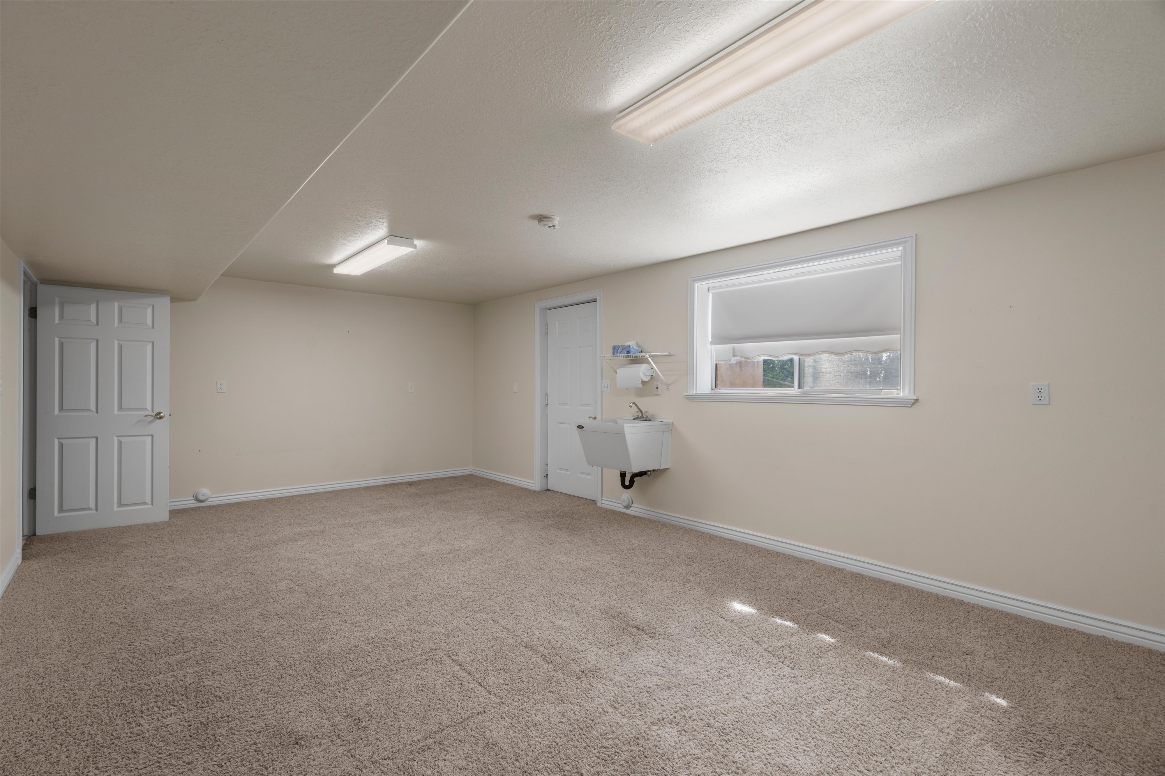 Spacious room featuring carpet flooring, neutral wall tones, and white trim