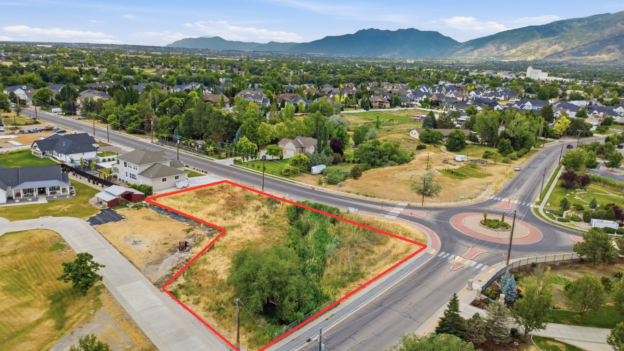 Expansive corner lot featuring direct road frontage and natural landscaping