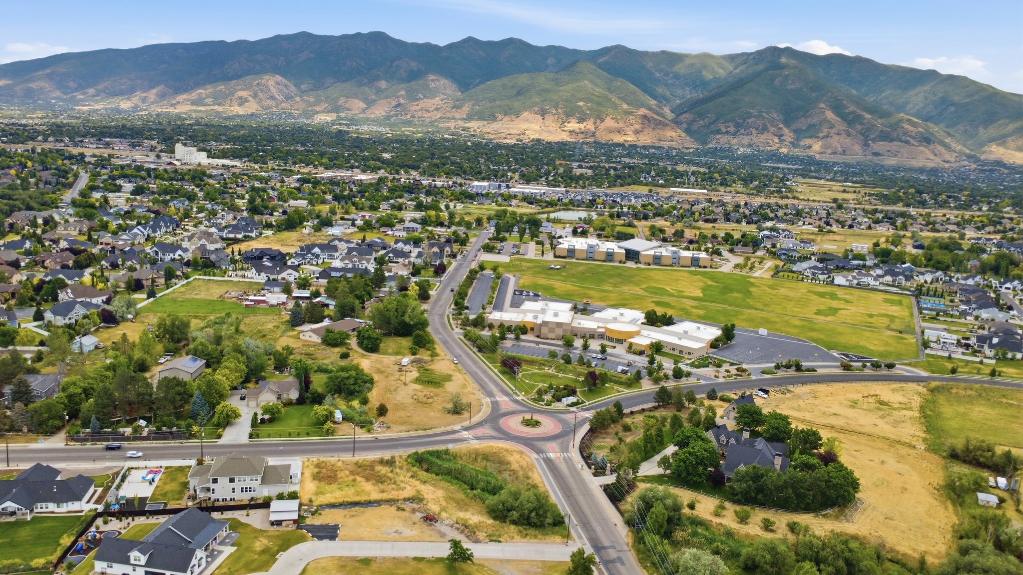 Expansive residential area featuring established homes, verdant landscapes, and mountainous terrain