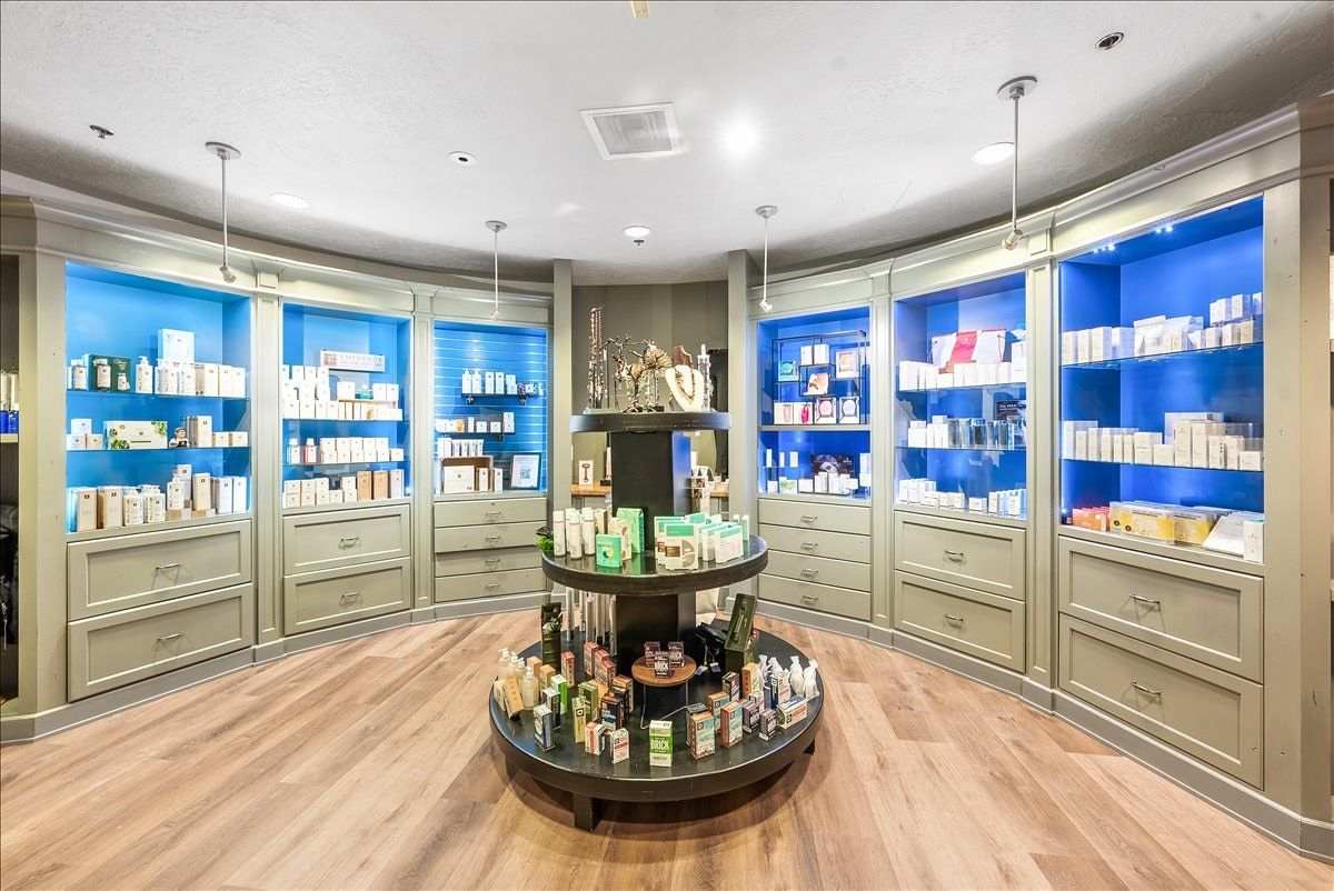 Curved custom cabinetry with integrated lighting and display shelving, complemented by wood-finish flooring