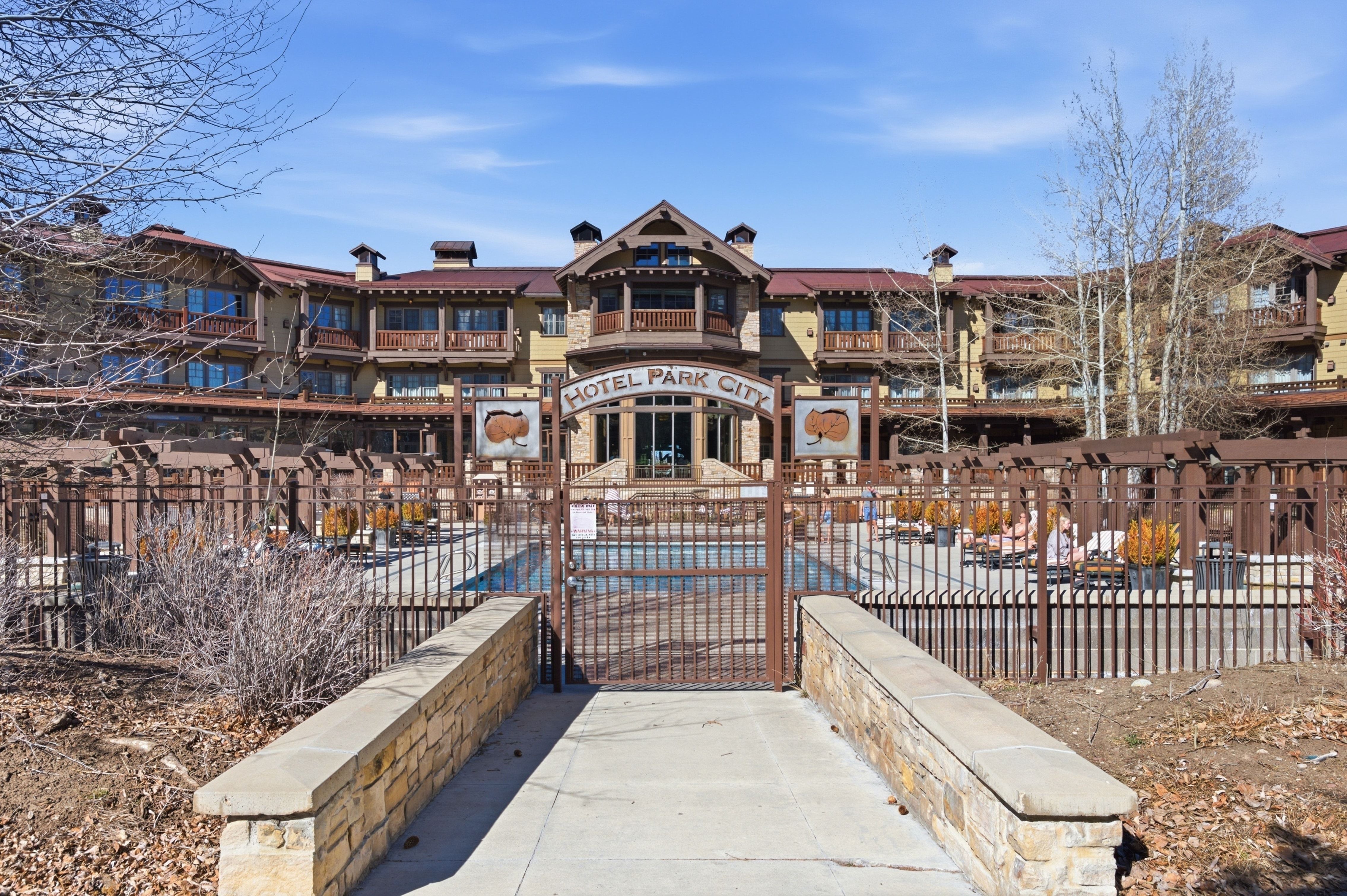 Multi-story building featuring stone and wood siding, multiple balconies, and a distinctive roofline