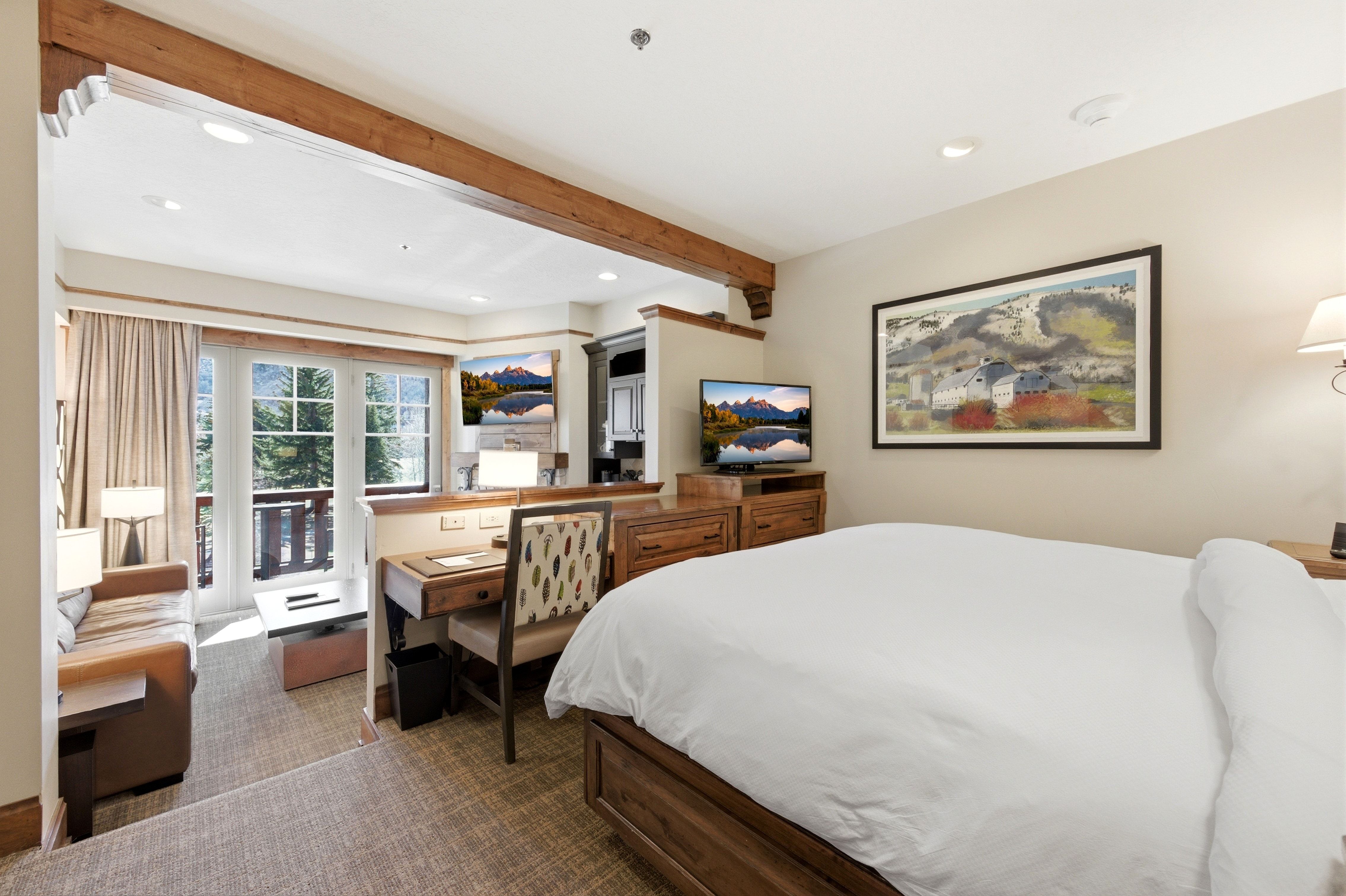 Bedroom featuring a wood-finish bed frame, recessed lighting, and an adjacent partitioned sitting area