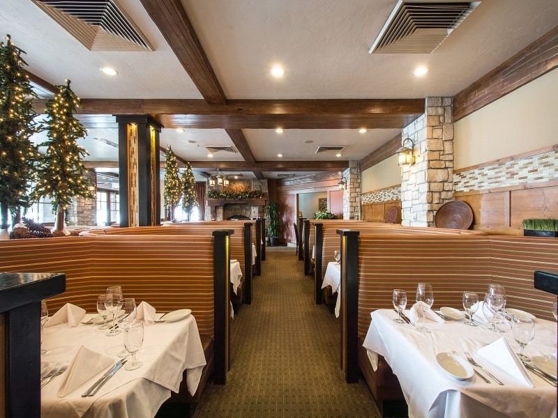 Dining area with booth seating and overhead wood-finish beams