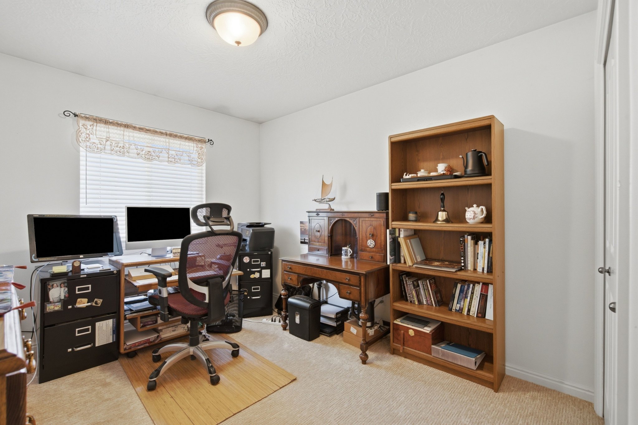 Carpeted room with a ceiling-mounted light fixture