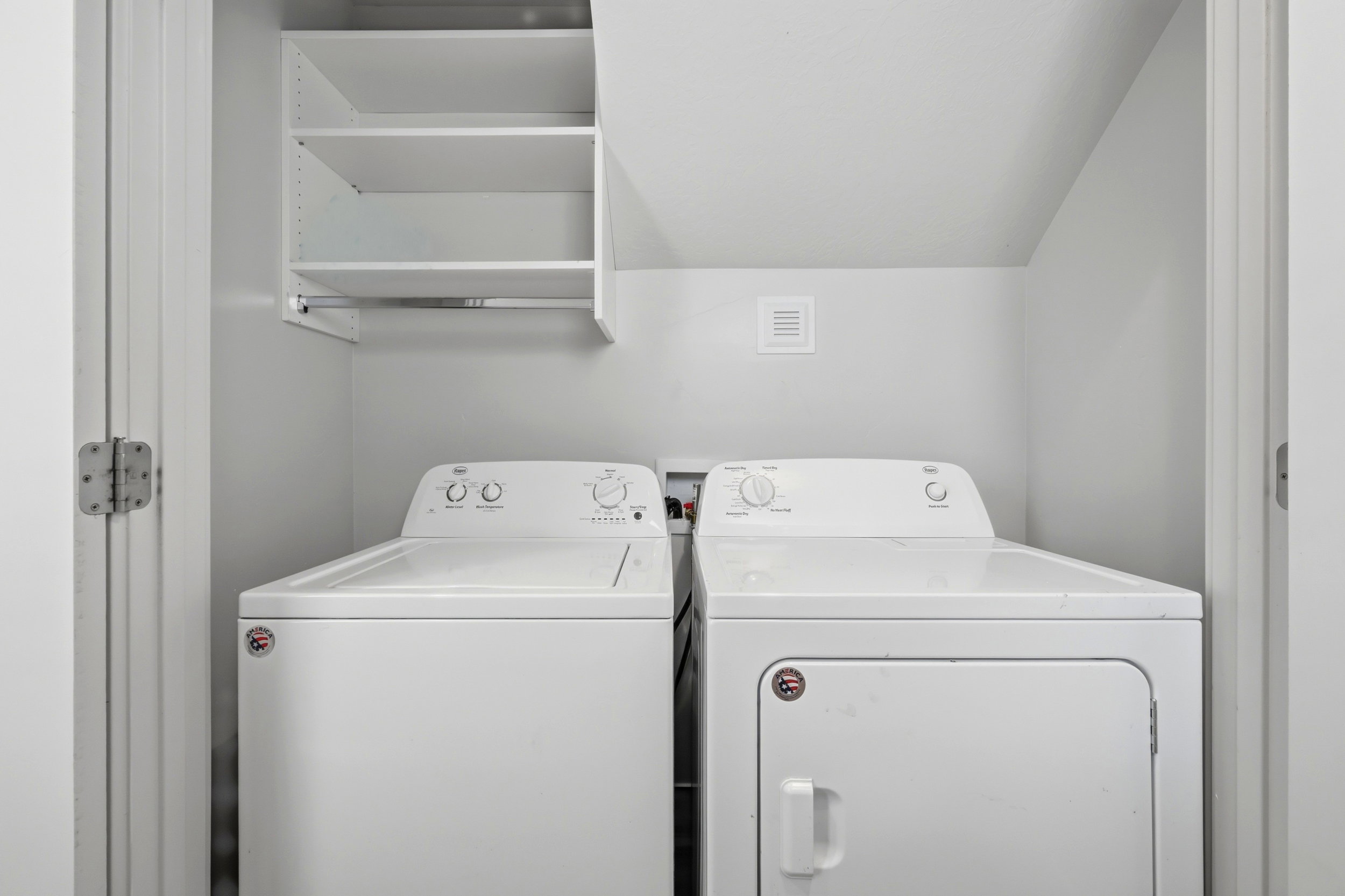 Dedicated laundry closet featuring a top-load washer and front-load dryer