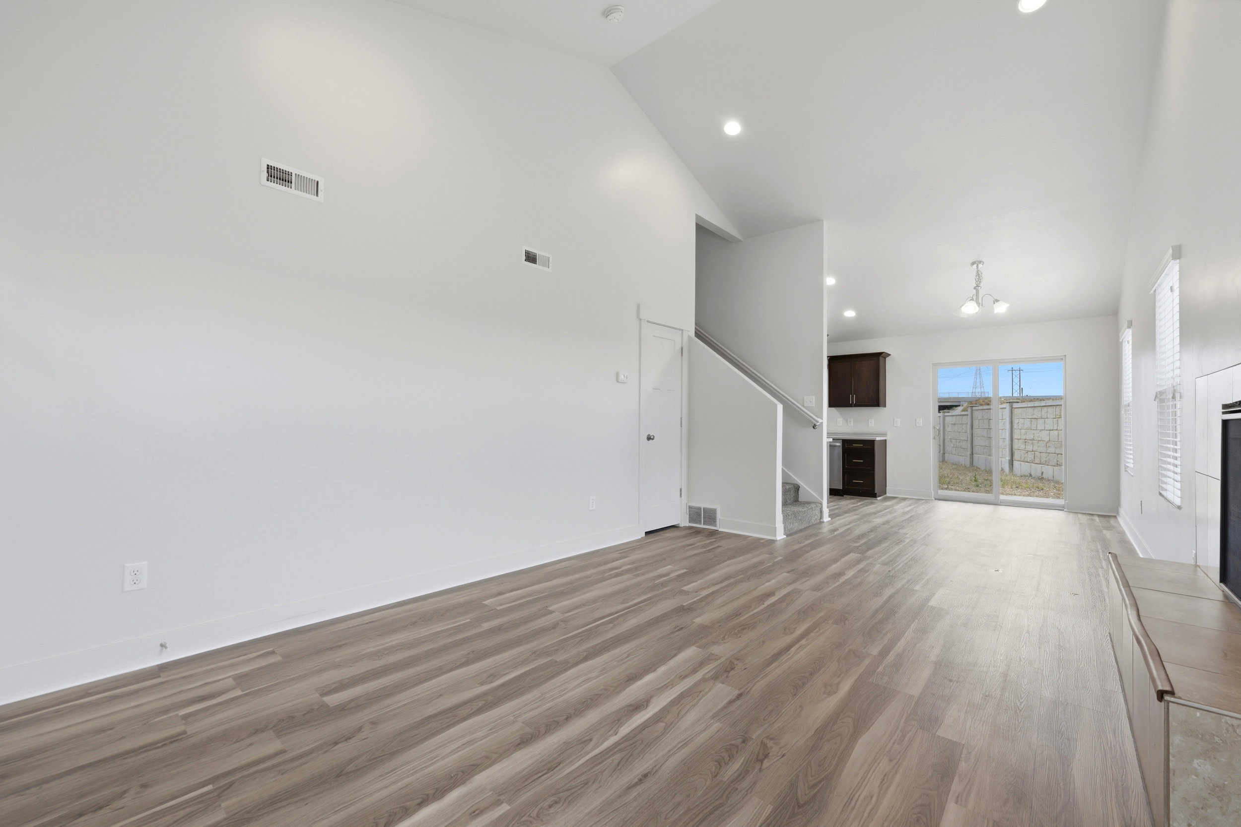 Open-concept living space with wood-finish flooring and high vaulted ceilings