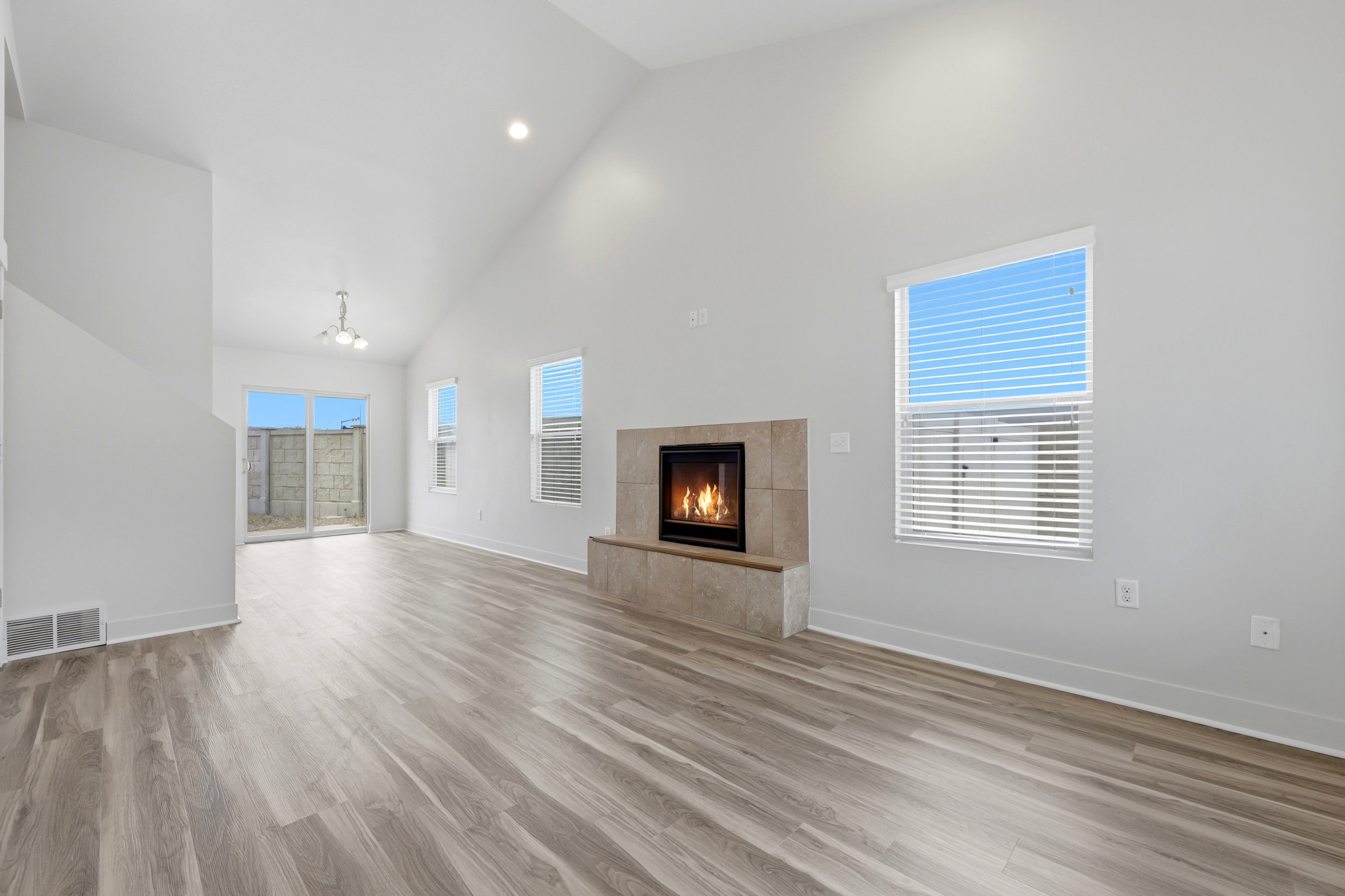 Spacious living area featuring a vaulted ceiling and wood-finish flooring