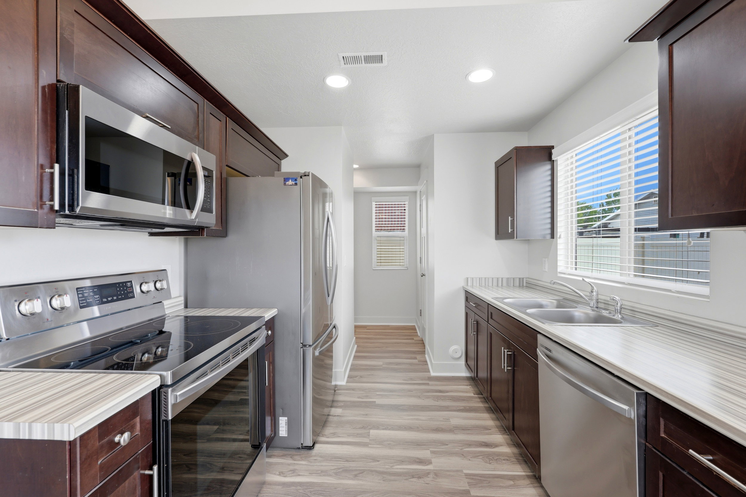 Galley kitchen featuring wood-finish cabinetry and stainless steel appliances