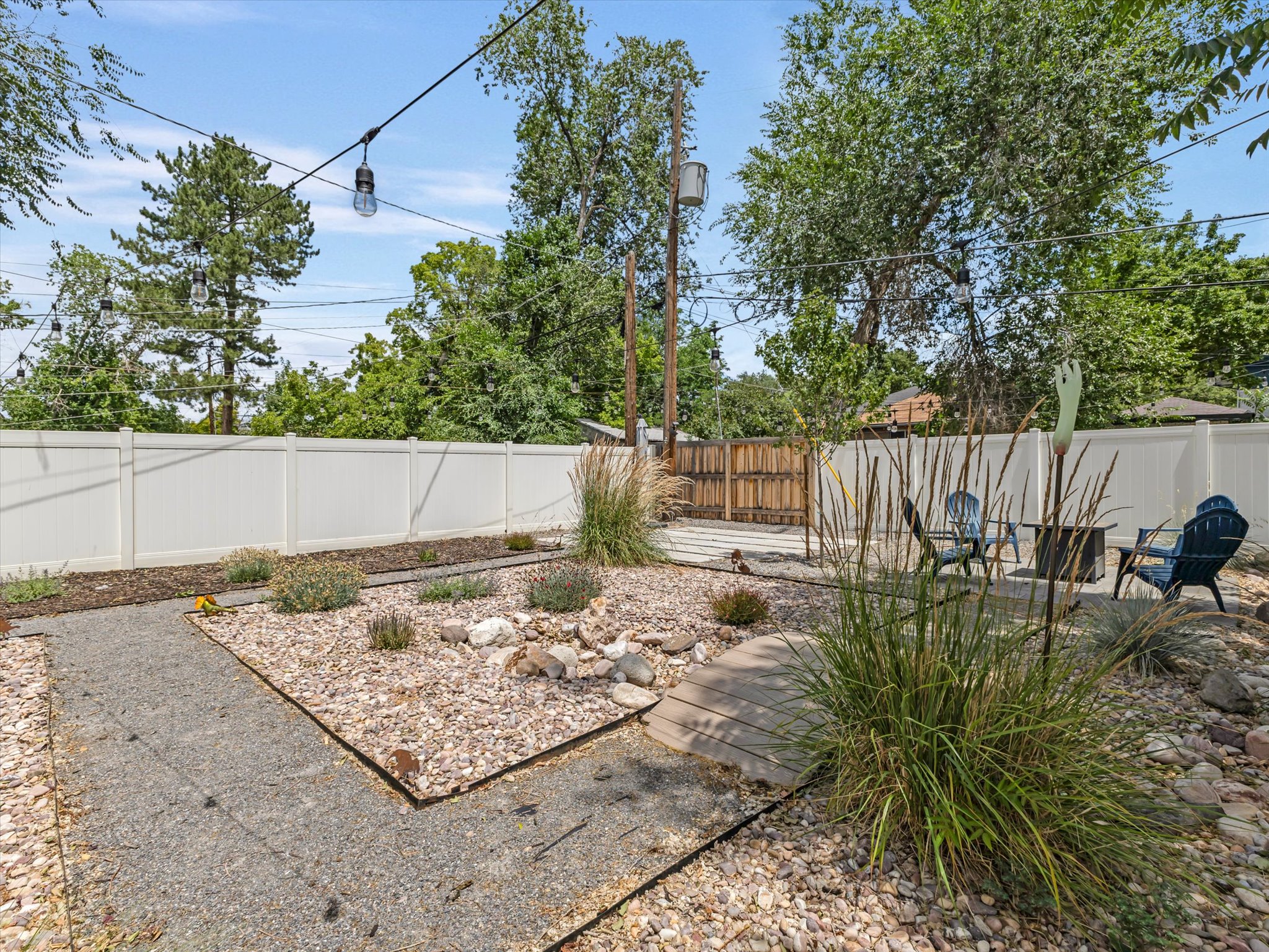 Private backyard featuring white privacy fencing and a gravel patio area