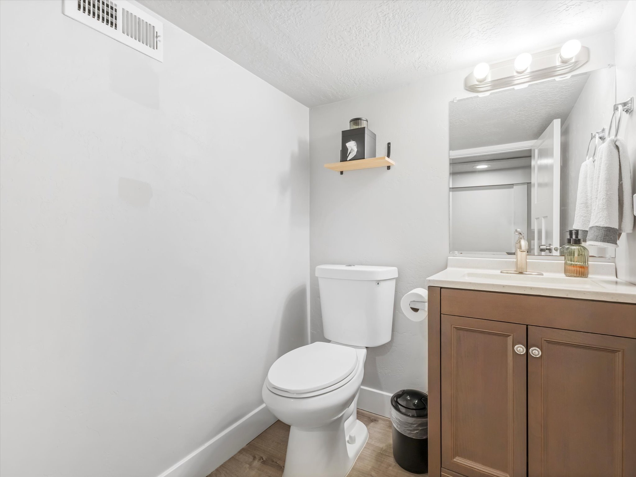 Bathroom featuring a vanity with brown wood-finish cabinetry, a white countertop, and a rectangular sink